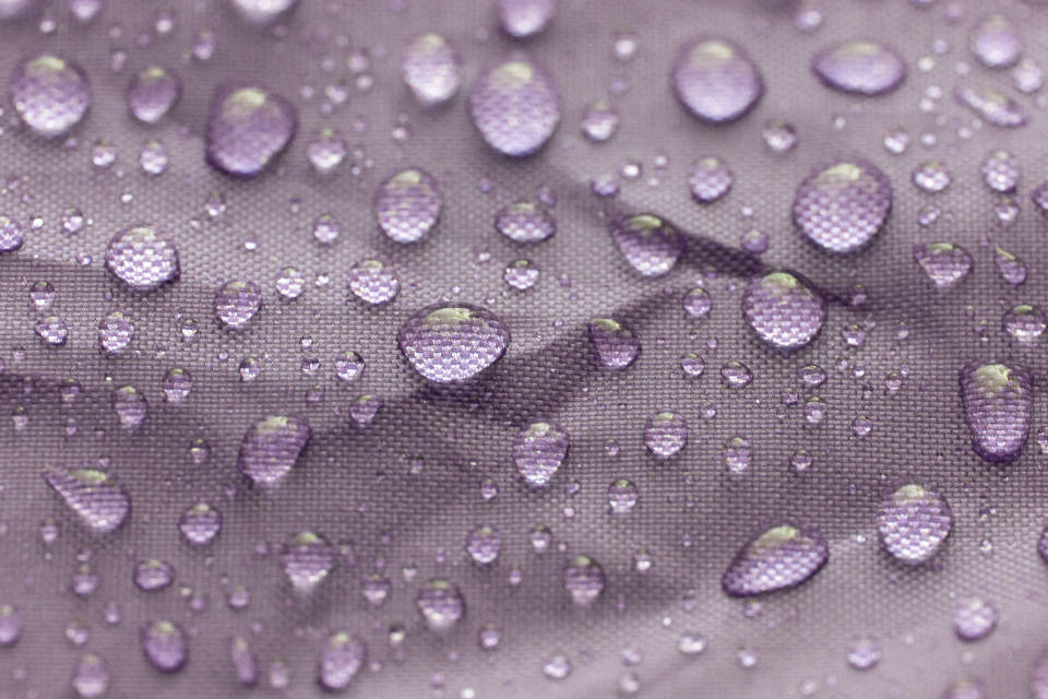 Water Droplets On Purple Fabric Background