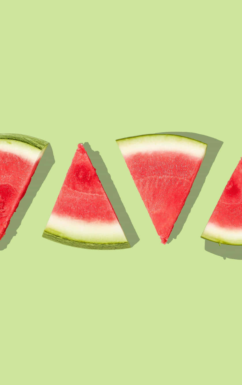 Watermelon Slices In Triangles On A Green Background Background