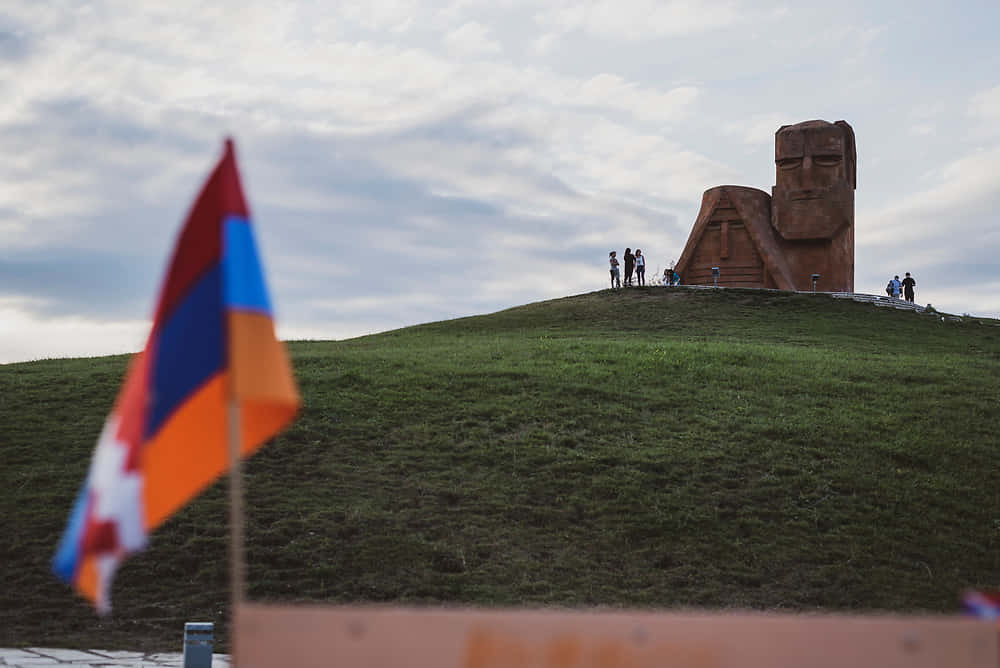 We Are Our Mountains Monument With Flag Background