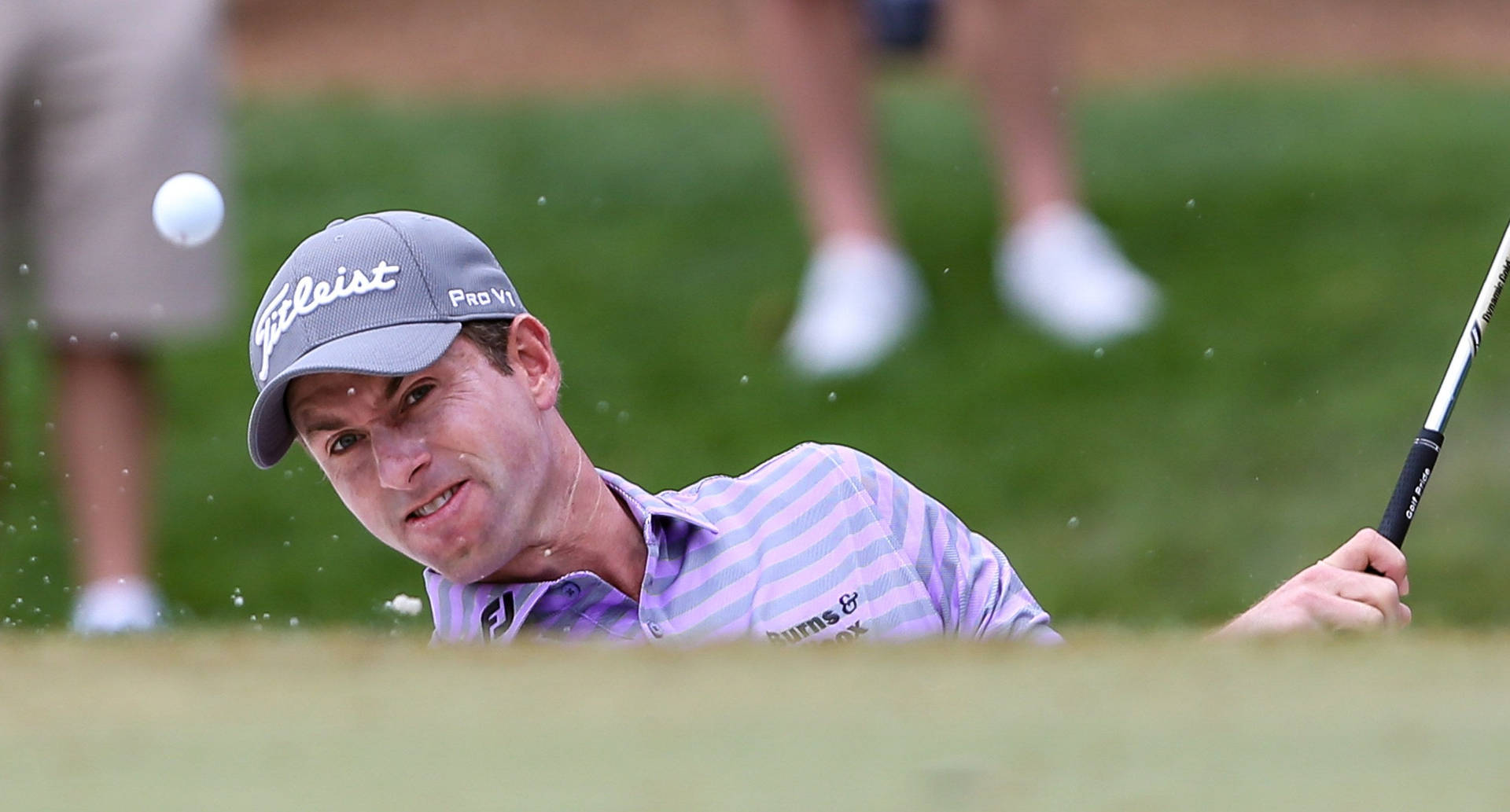 Webb Simpson Hitting A Golf Ball Hard Background