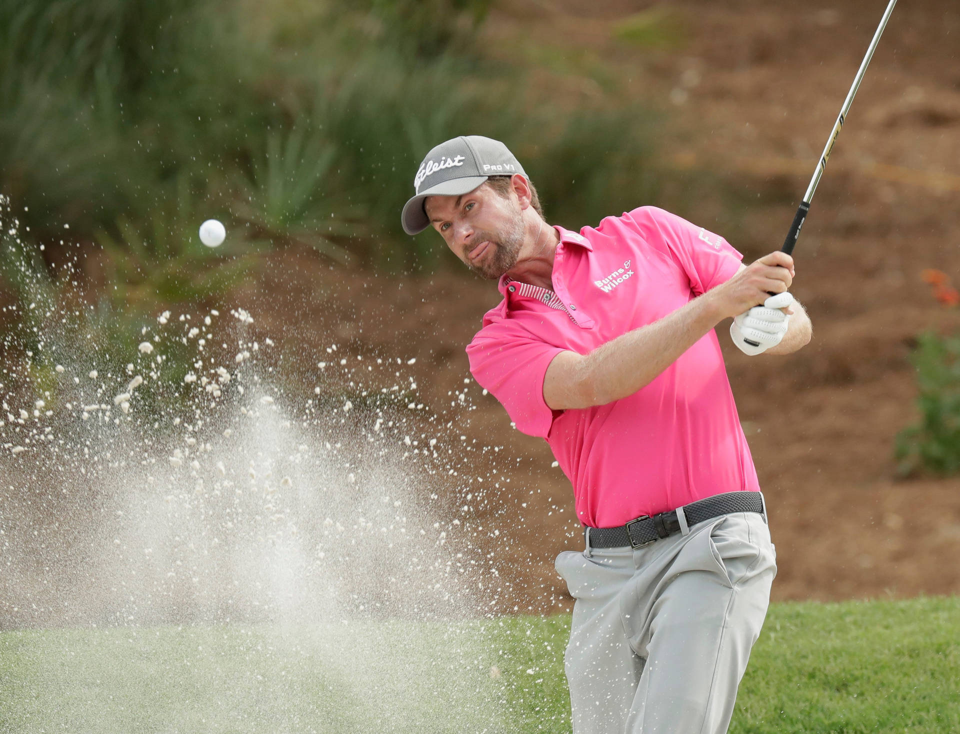 Webb Simpson Striking A Golf Ball From Sand Bunker