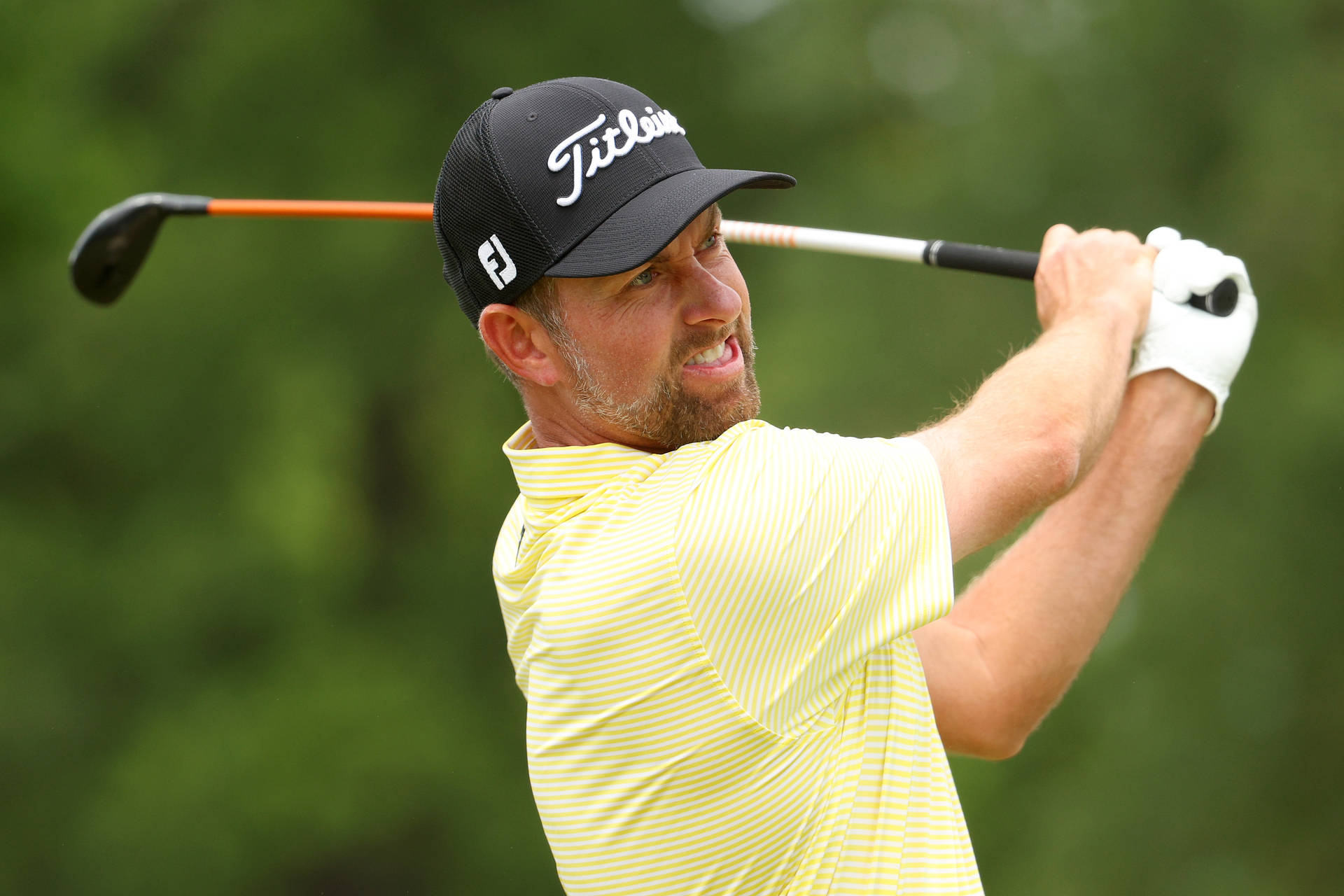 Webb Simpson Swinging A Silver And Orange Golf Club Background