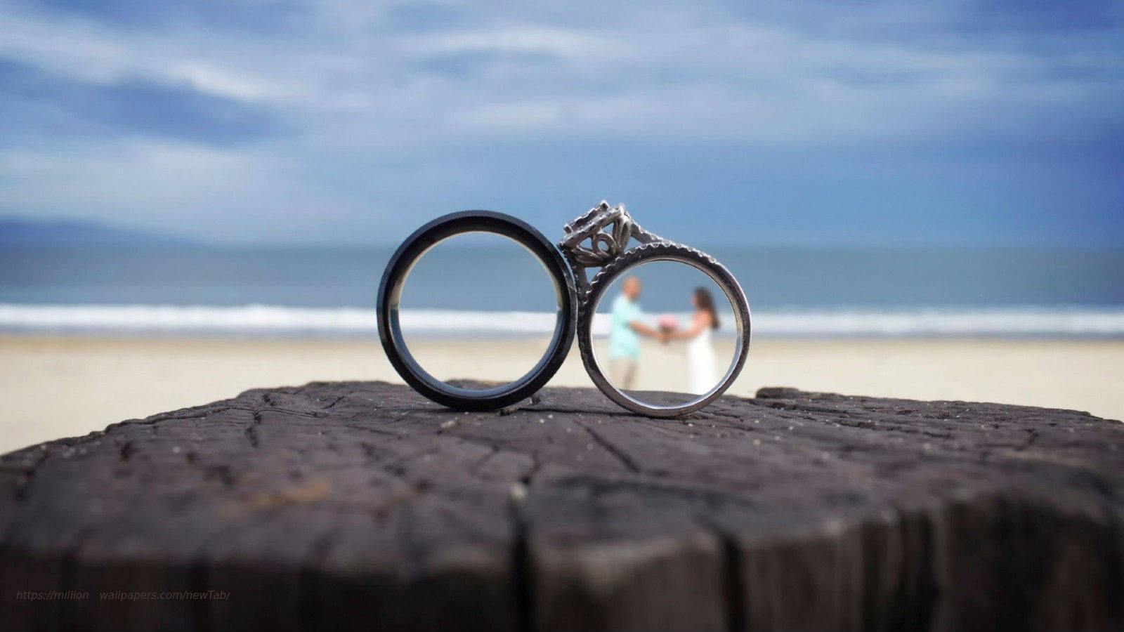 Wedding Rings On The Beach Background