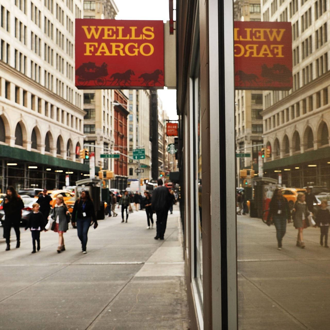 Wells Fargo Bank Sign On Busy Street With Commuters Background