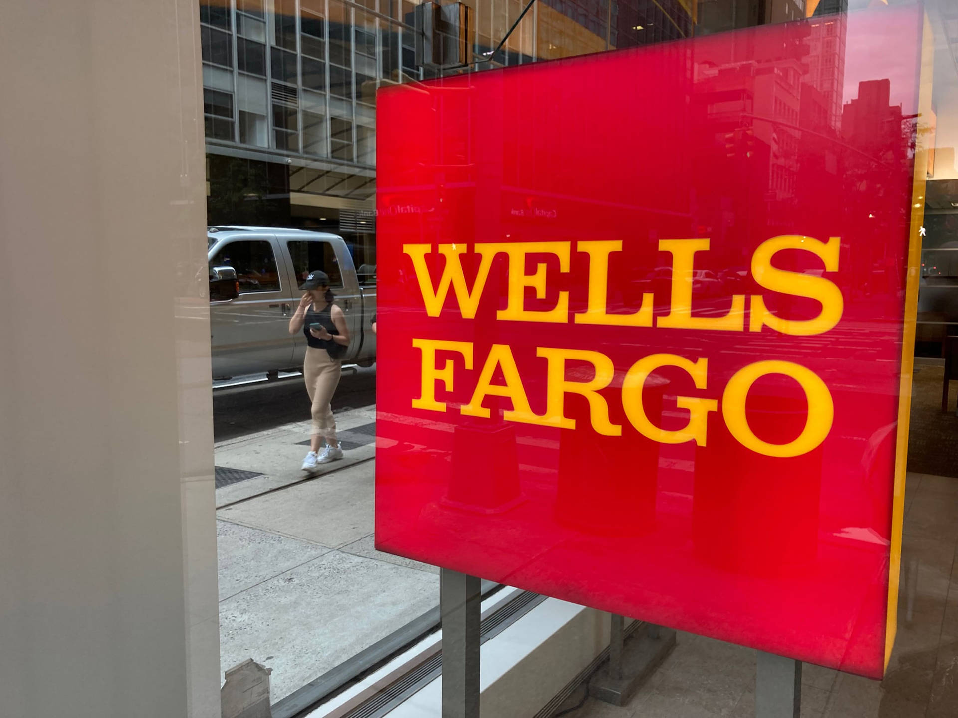 Wells Fargo Company Sign Behind A Glass Wall Background