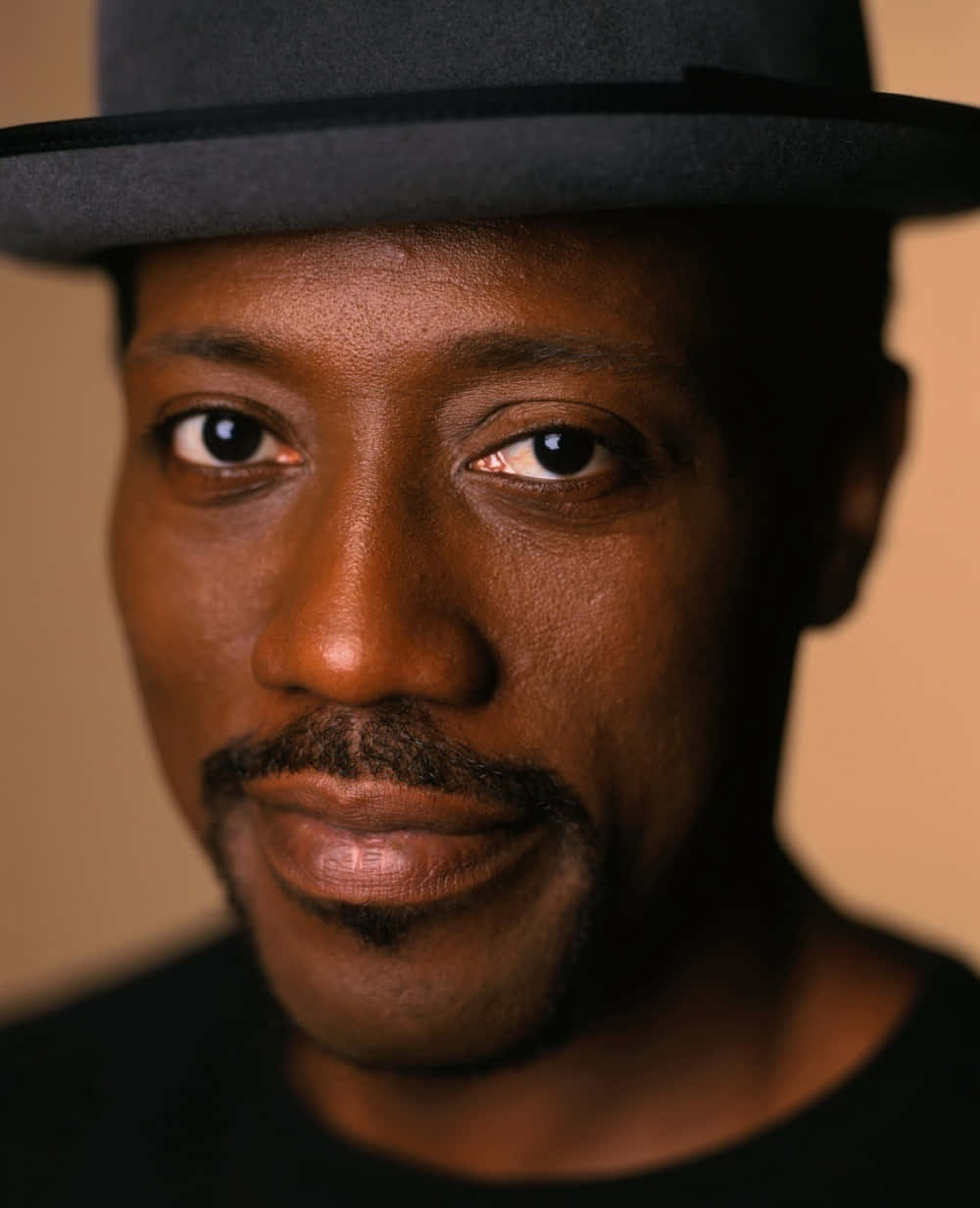 Wesley Snipes Smiling In A Suave Attire Background