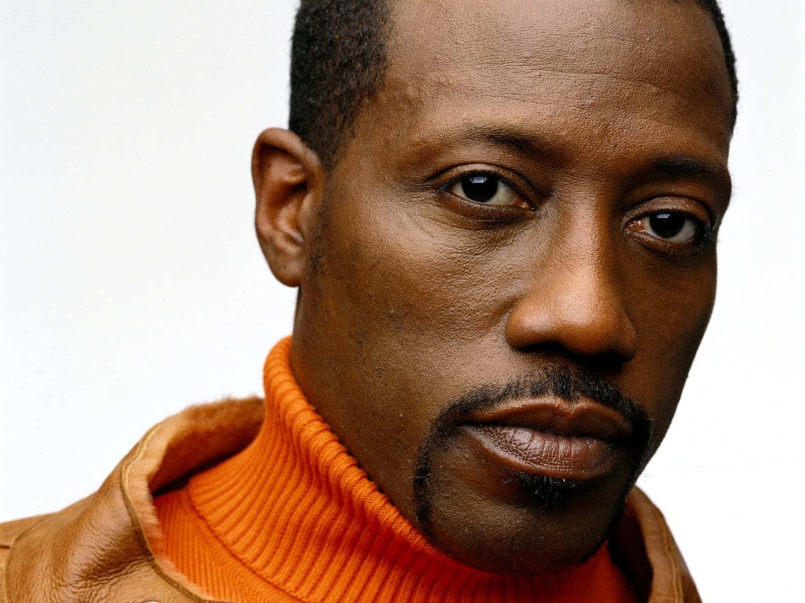 Wesley Snipes Sporting A Fierce Look In A Dark Outfit Background