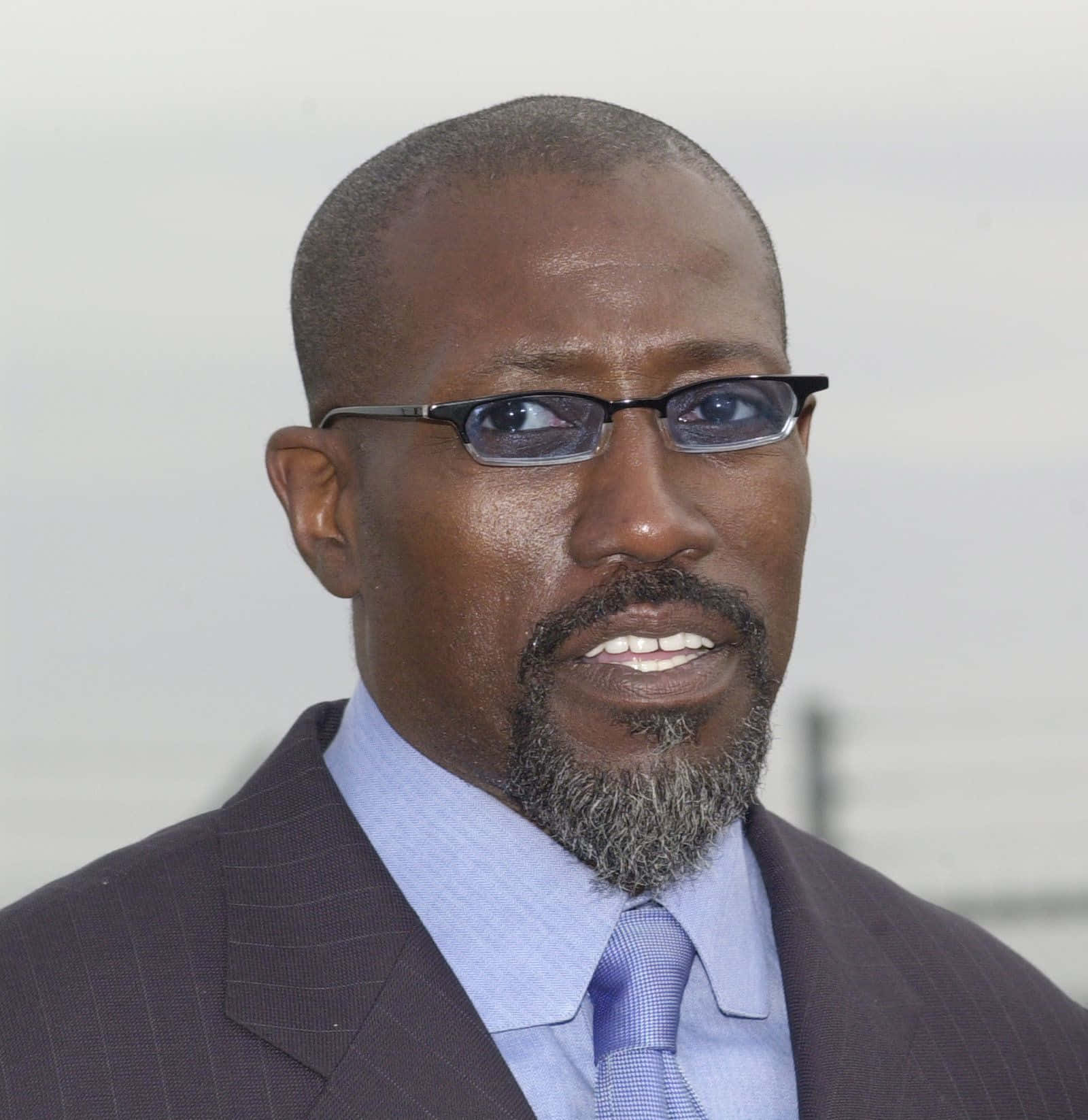 Wesley Snipes Striking A Pose In A Sharp Suit Background