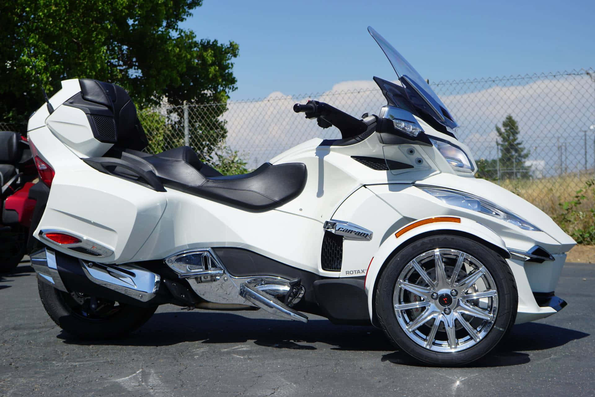 White Can Am Spyder Roadster Parked Outdoors Background