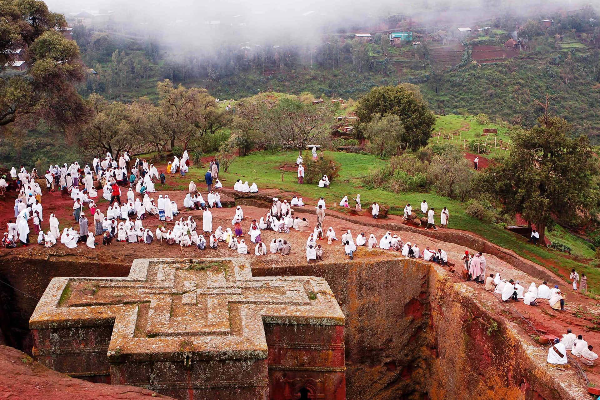 White-clothed Orthodox Christians Gather Around Lalibela's St. George Church Background