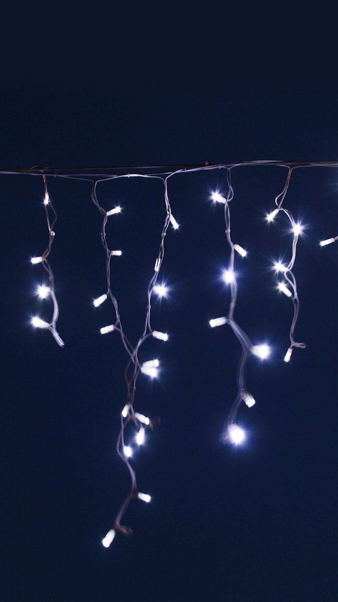 White Led String Lights Hanging From A Wire Background