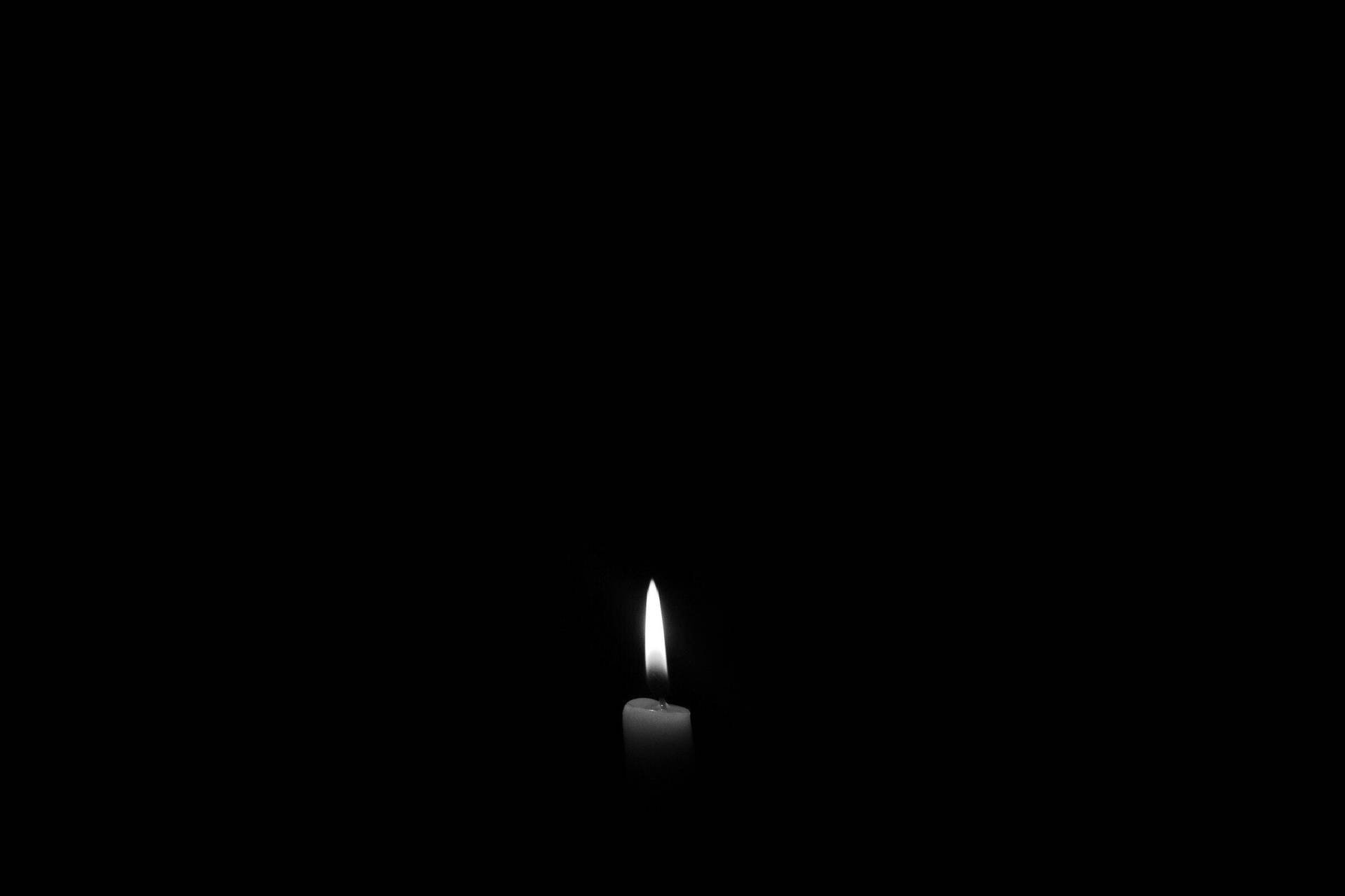 White Lit Candle Over Dark Screen Background