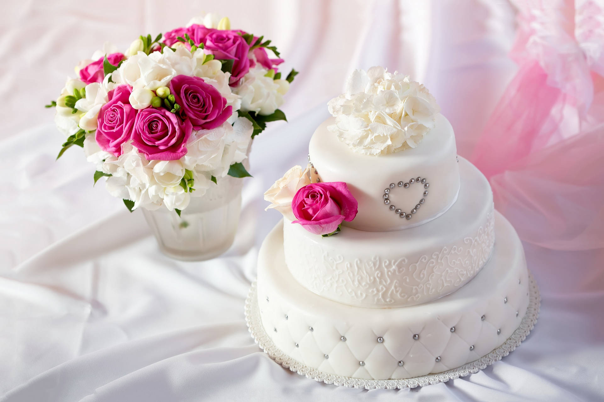 White Round Wedding Cake With Beads Near Roses Background