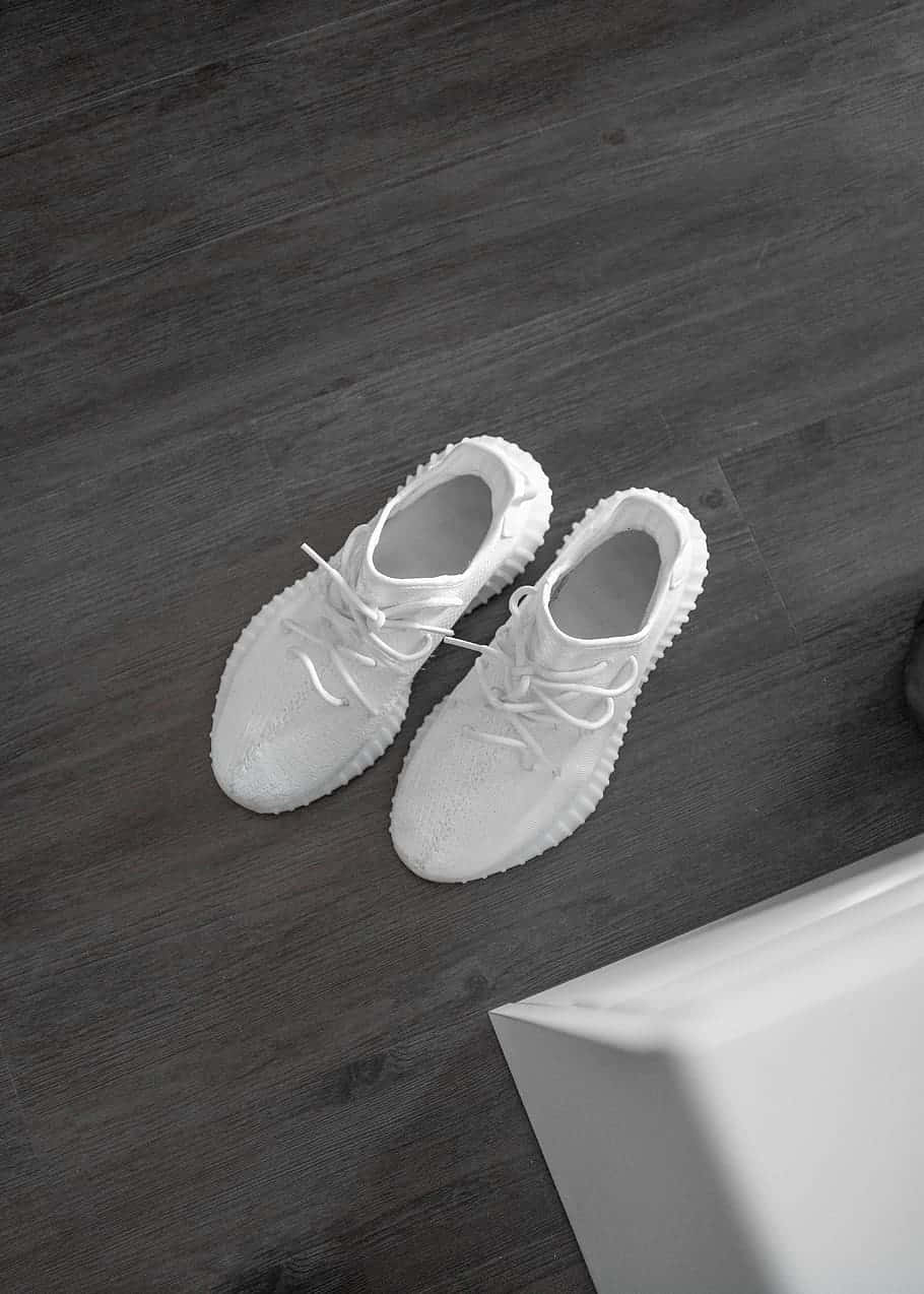 White Yeezy Shoes On The Wooden Floor Background