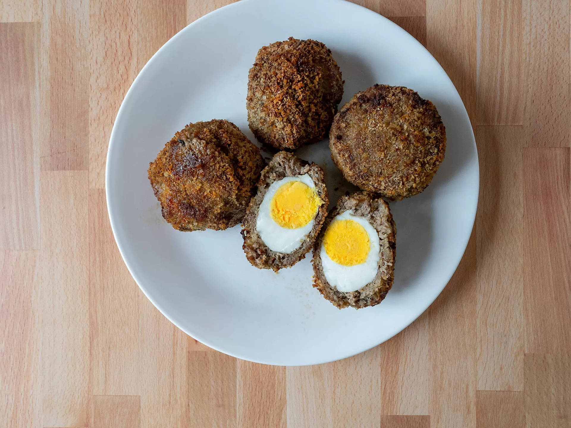 Whole And Sliced Traditional British Scotch Eggs Dish Background