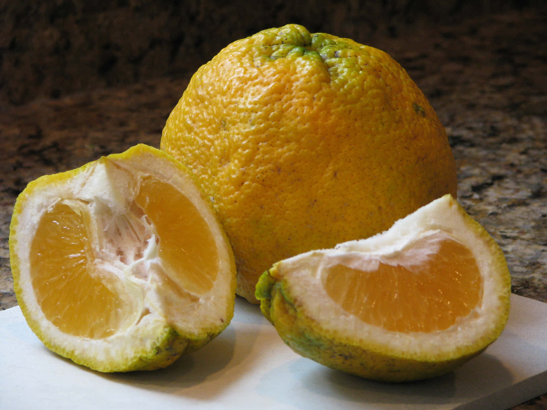 Whole Ugli Citrus Fruits And Slices Background