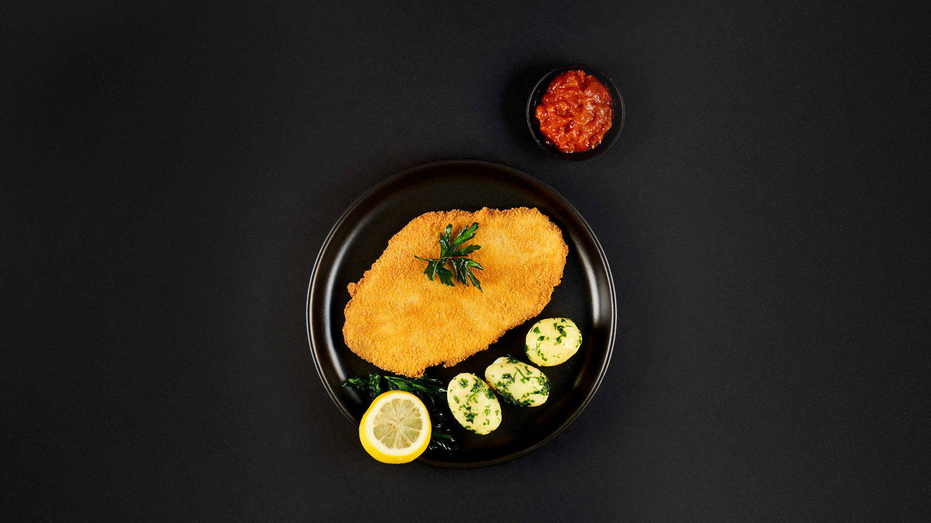 Wiener Schnitzel On Black Plate Background