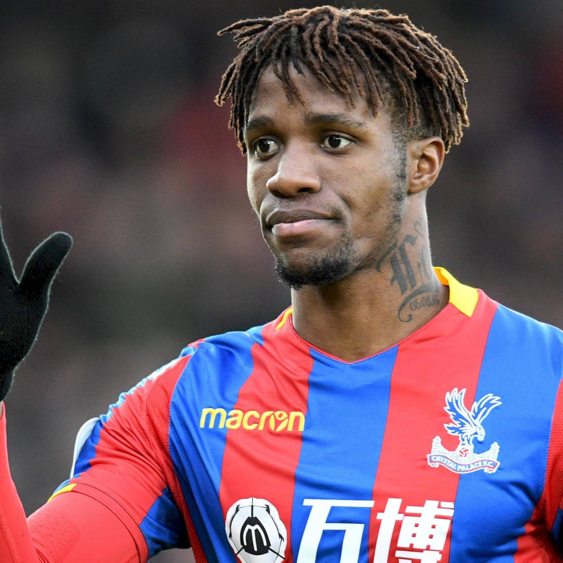 Wilfried Zaha Flaunts His Unique Hairstyle In A Casual Fashion Background