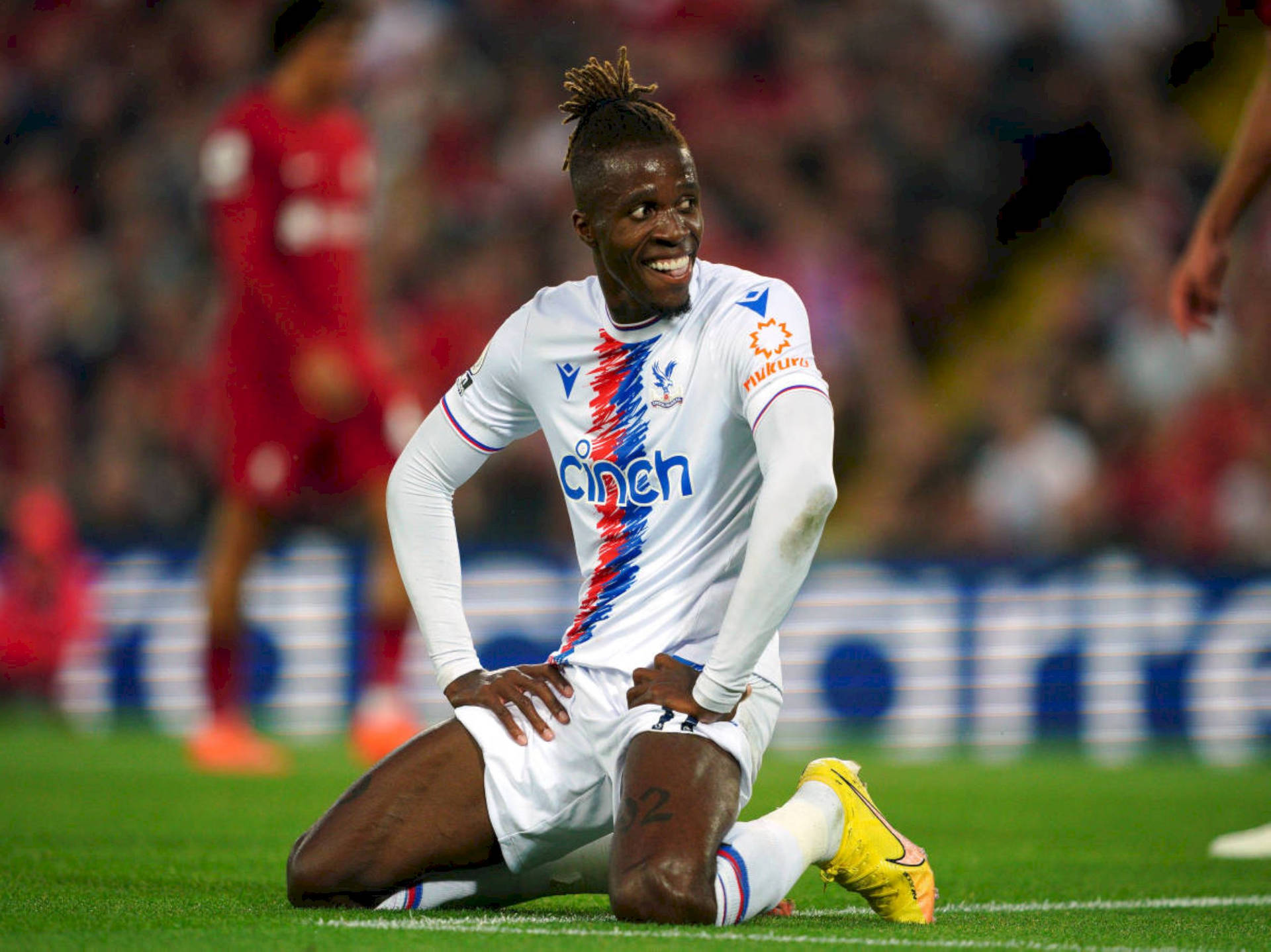 Wilfried Zaha Kneeling On Ground Background