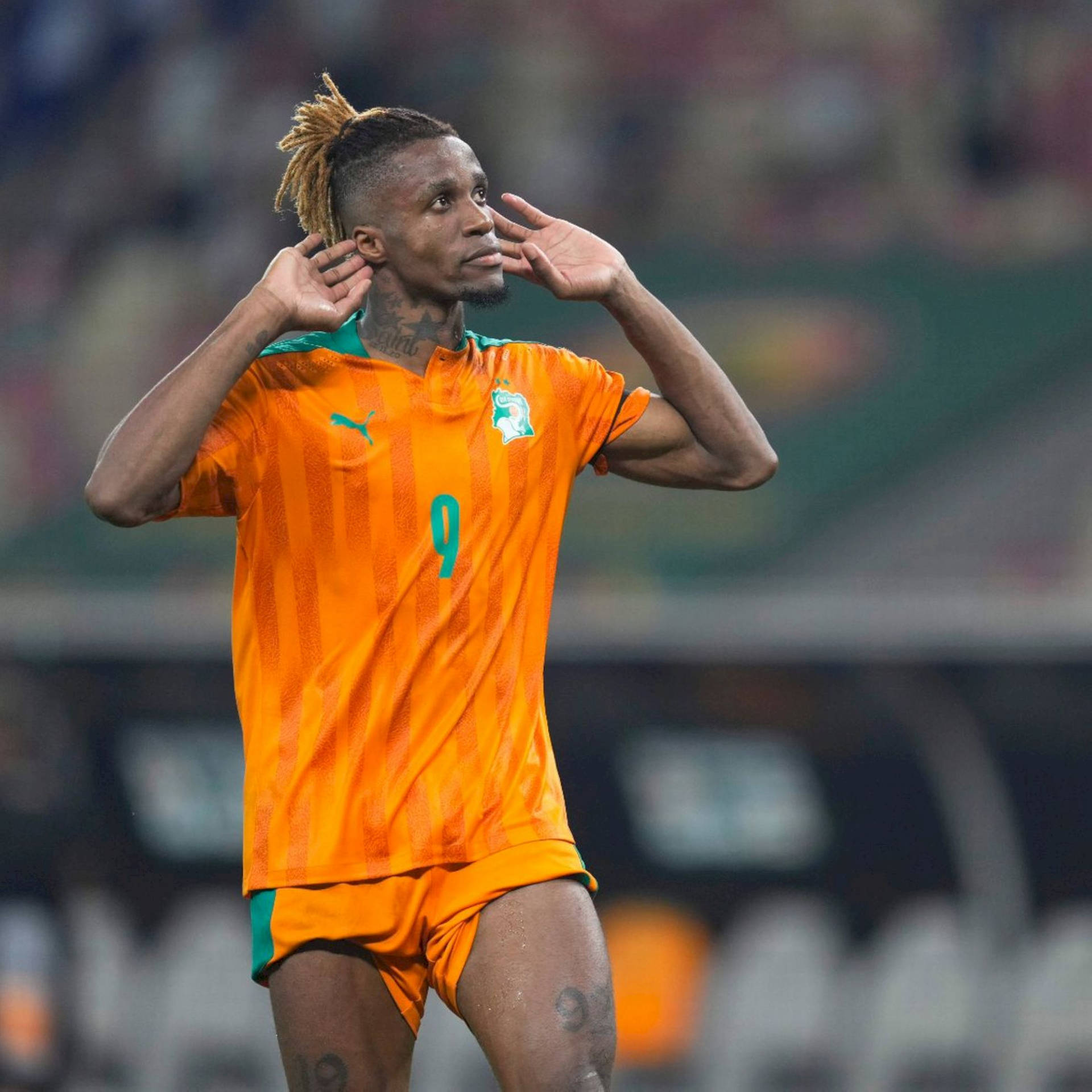 Wilfried Zaha Wearing Orange Uniform Background