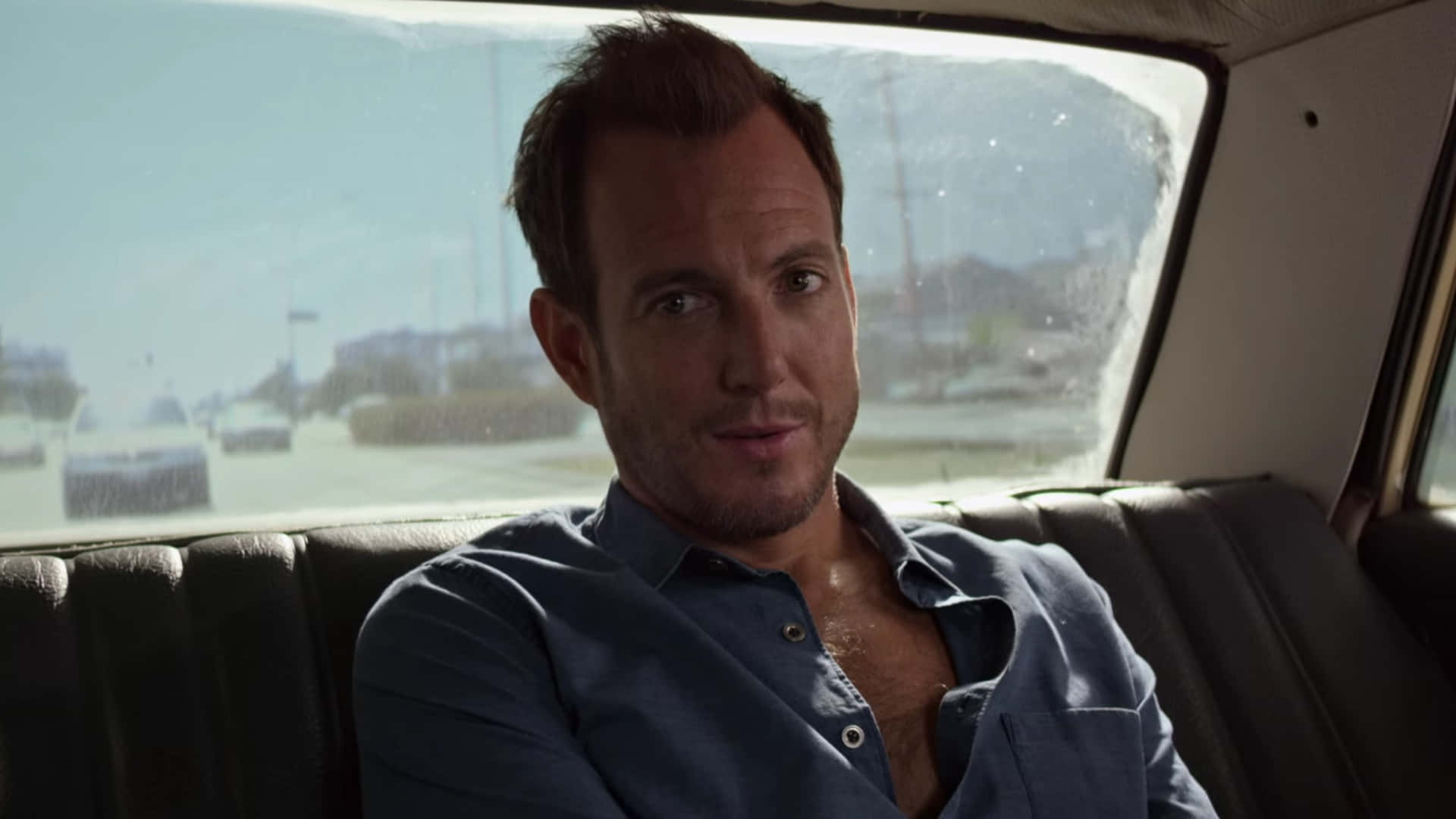 Will Arnett Strikes A Thoughtful Pose Against A Sleek Black Background Background