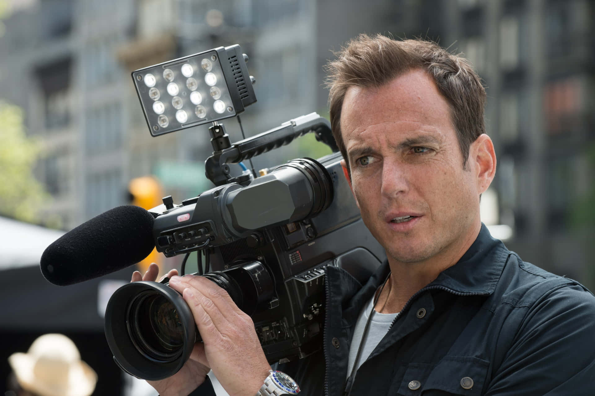 Will Arnett Striking A Casual Pose Against A Blue Background Background