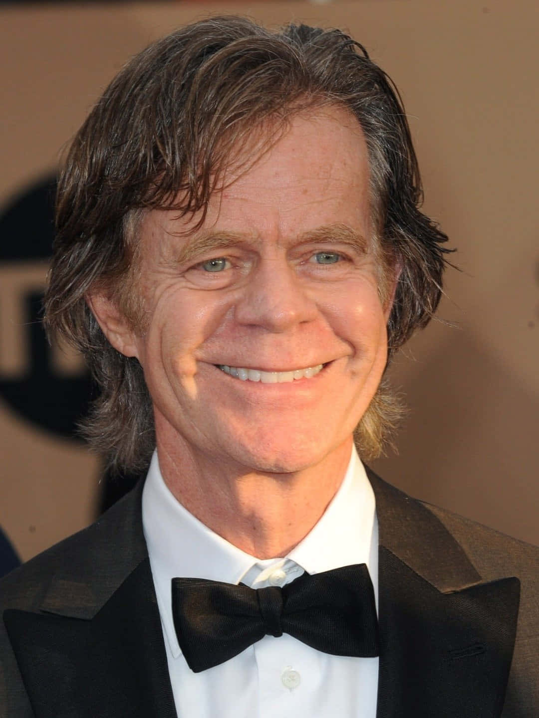 William H. Macy Posing In A Stylish Suit Background