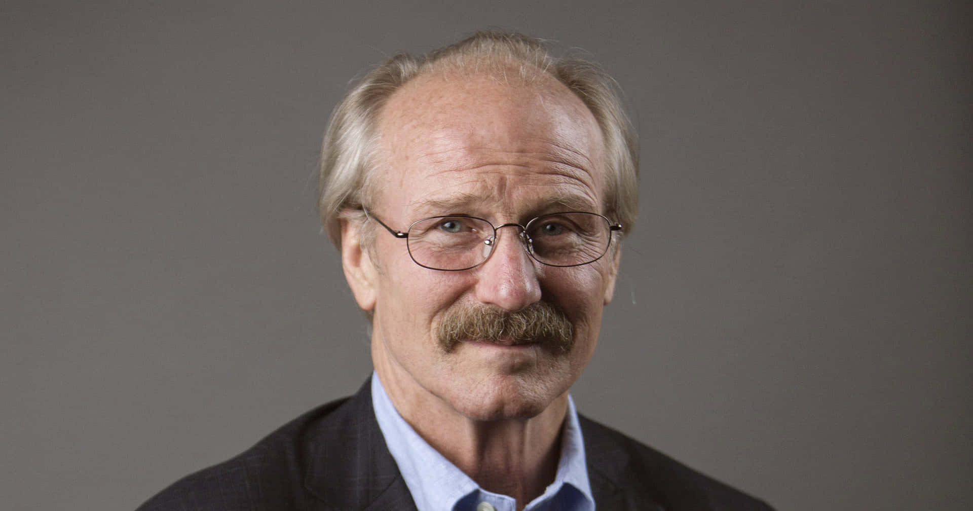 William Hurt Posing Against A Dark Background Background