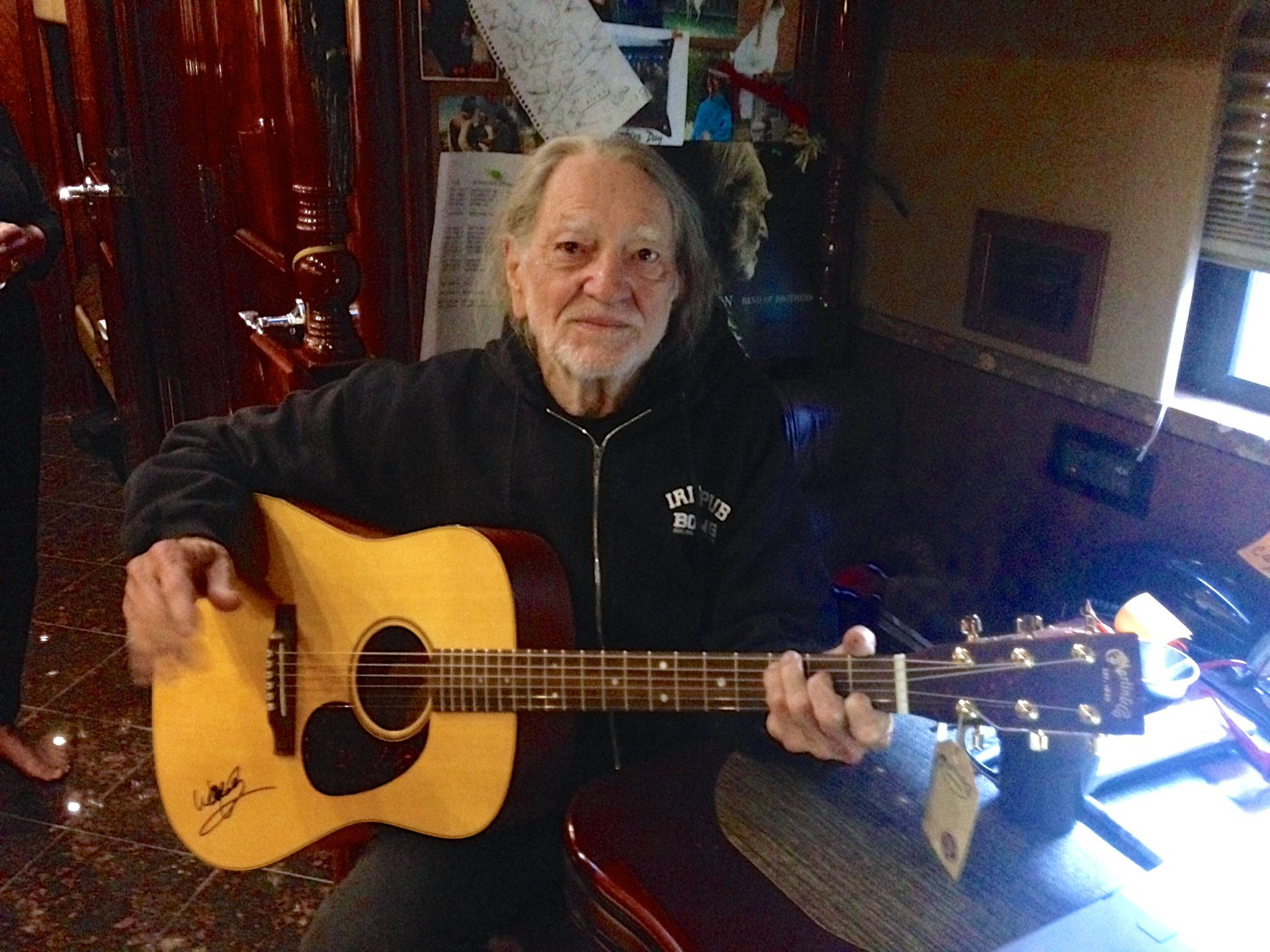 Willie Nelson Playing Guitar At Home Background