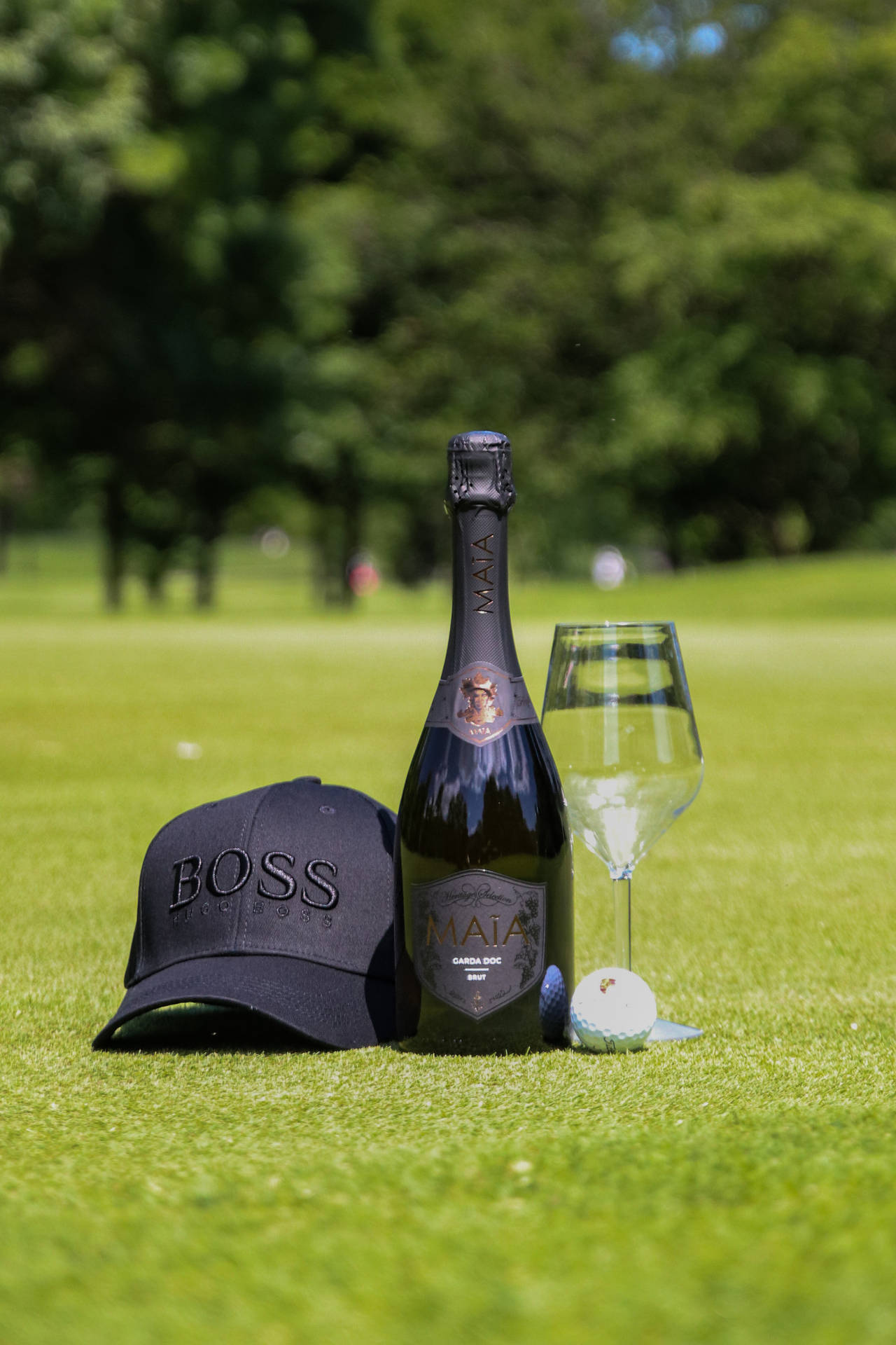 Wine Bottle Glass And Cap On Golf Course Background