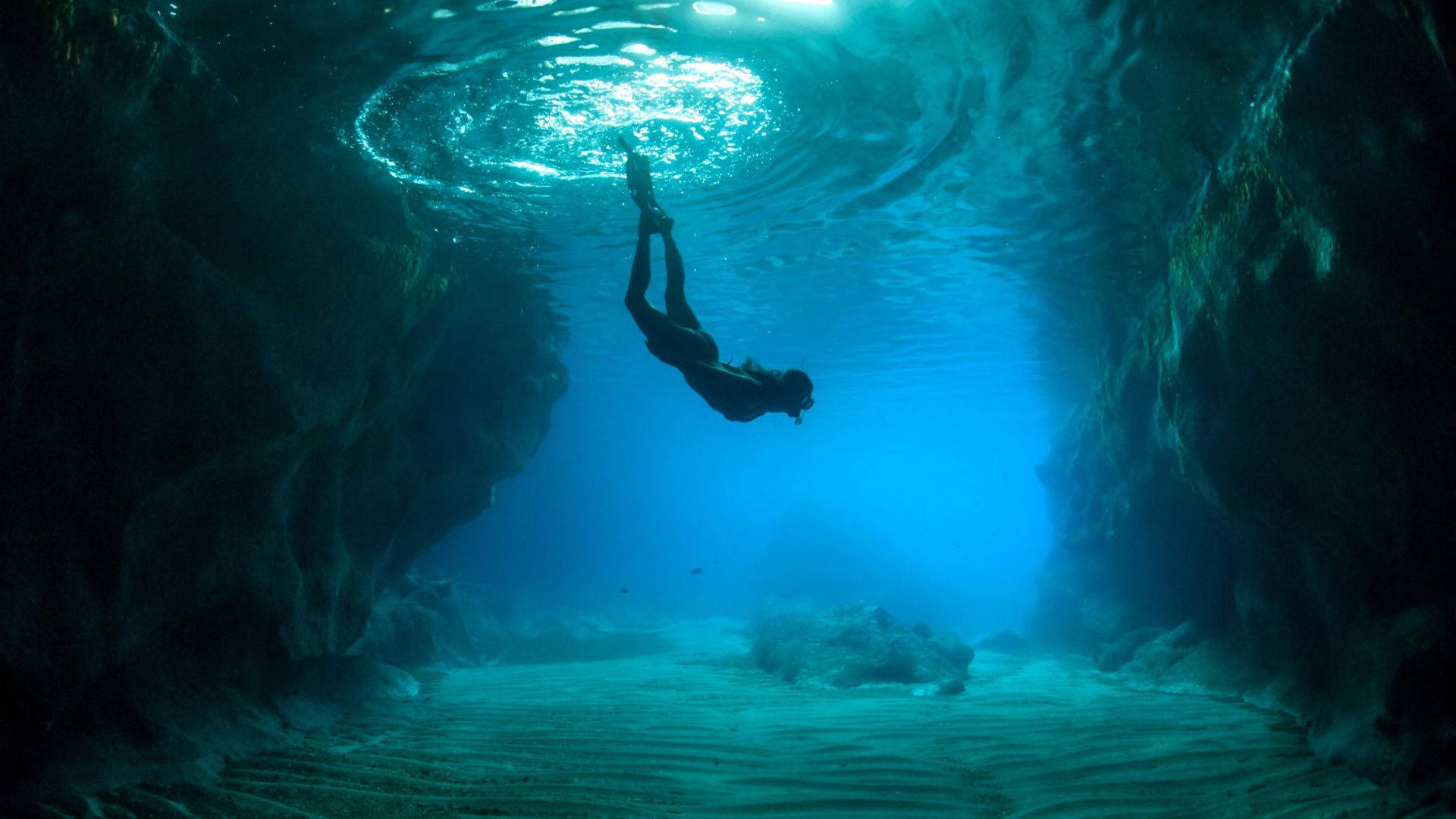 Woman Diving In Between Natural Underwater Structures