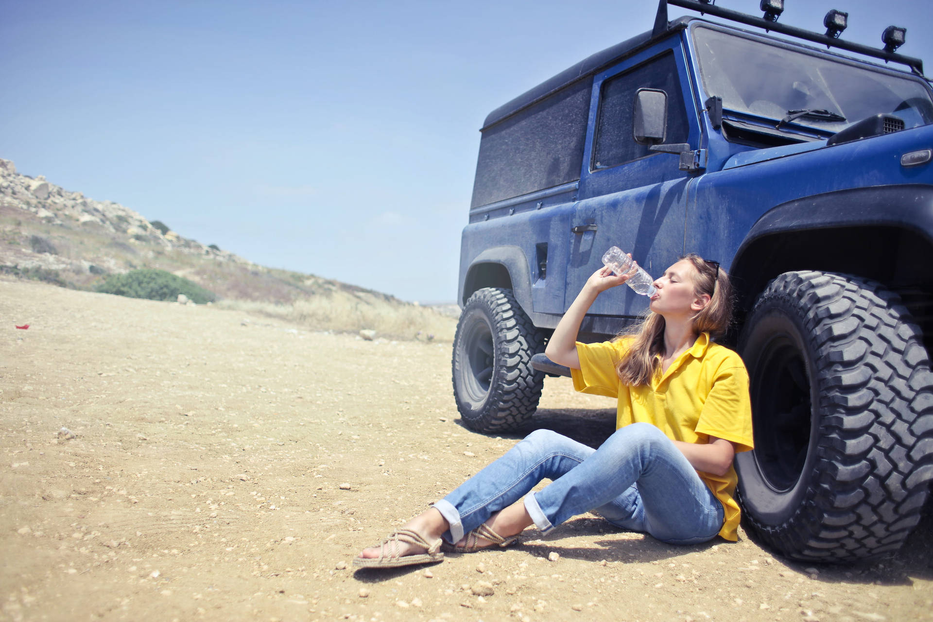 Woman Drinking Water Beside A Car