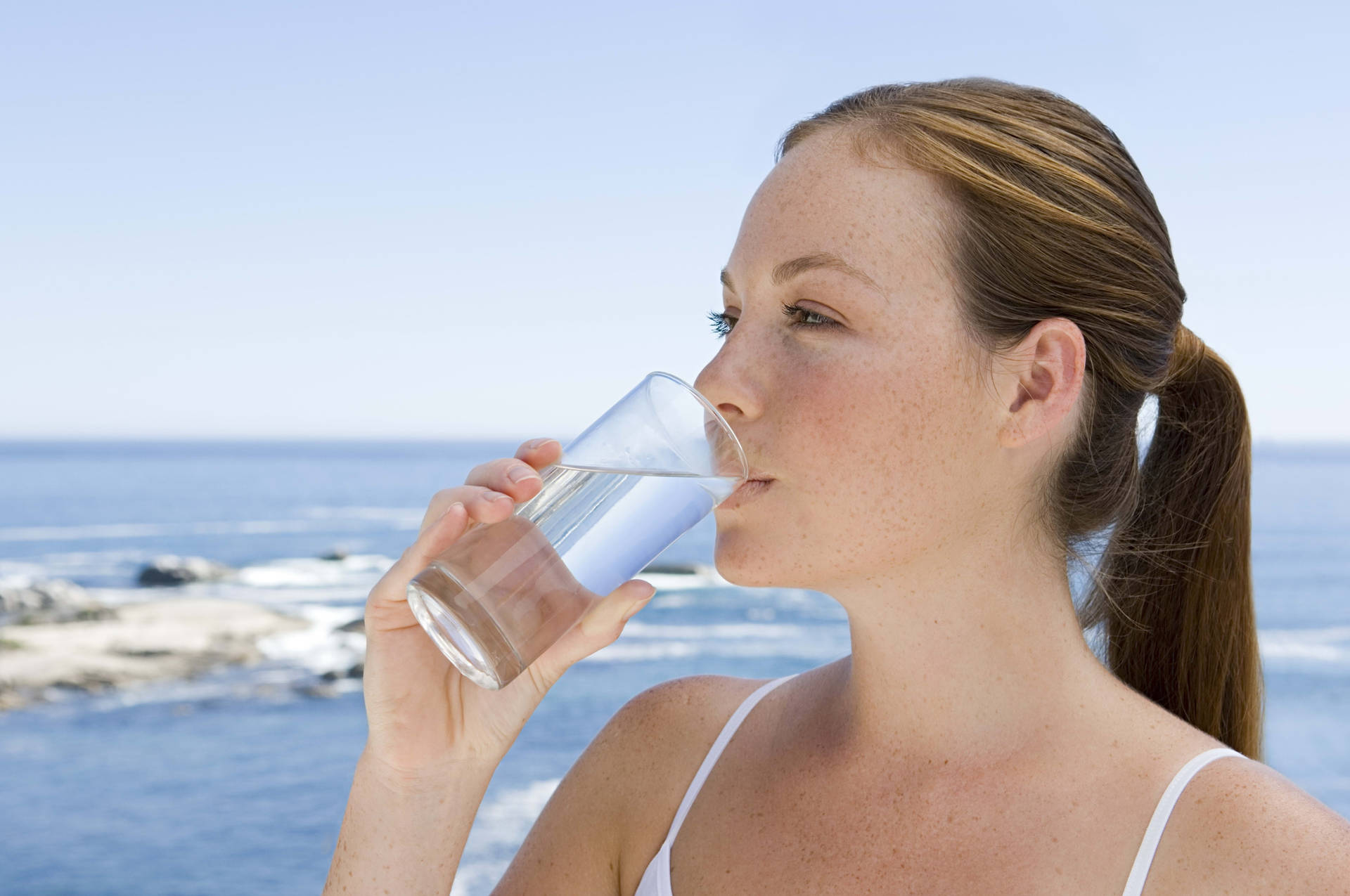 Woman Drinking Water On The Beach