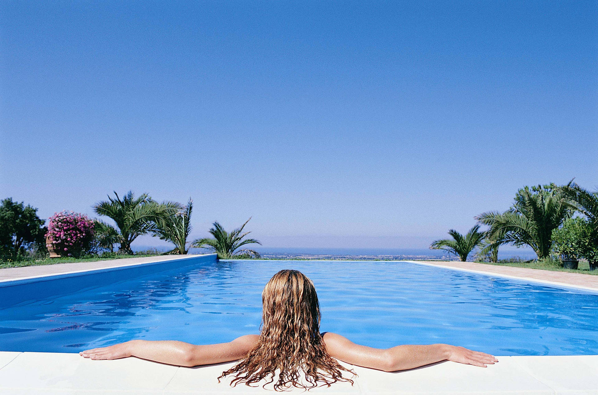 Woman Enjoying Solitude In A Swimming Pool Background