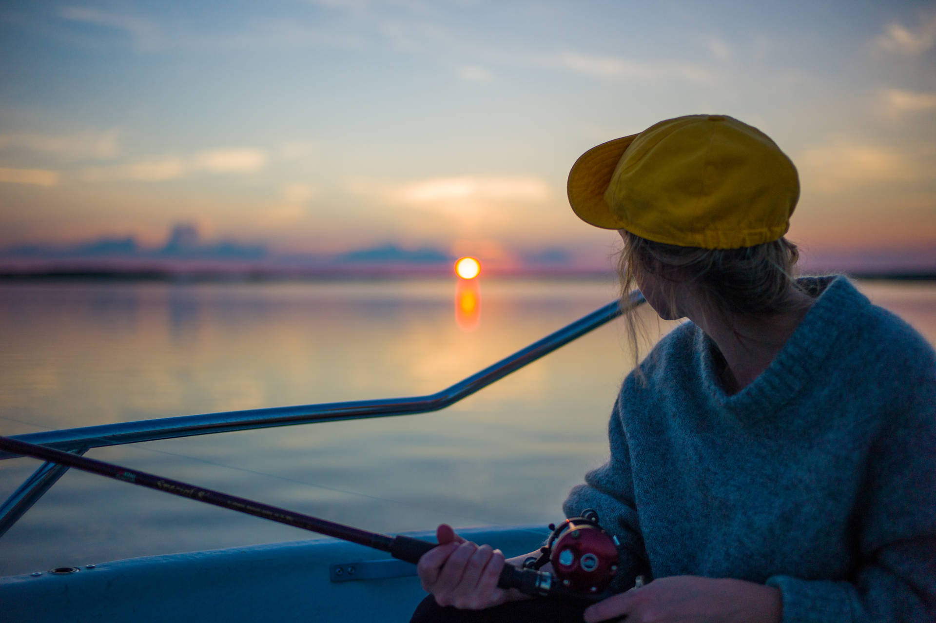 Woman Fishing At Finland Sunset Background