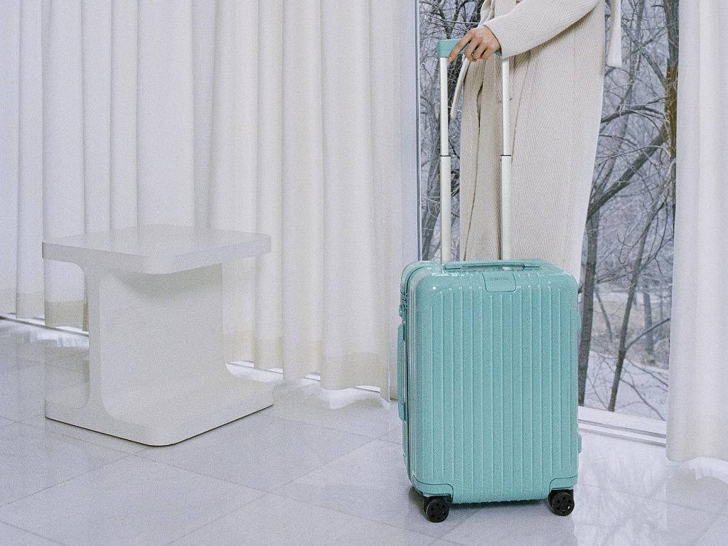 Woman Holding A Glacier Blue Rimowa