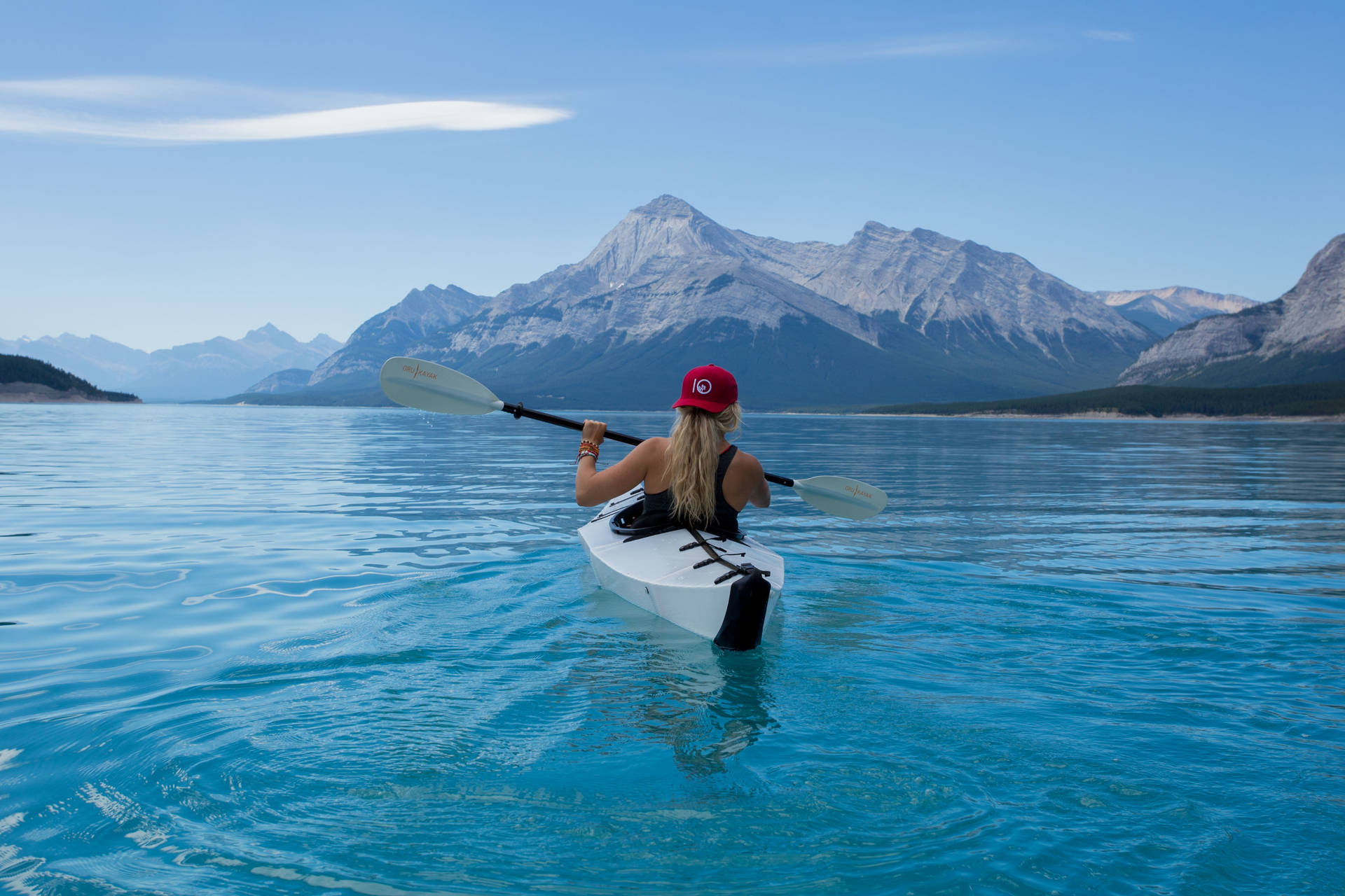 Woman Kayaking Over Beautiful Blue Water Background