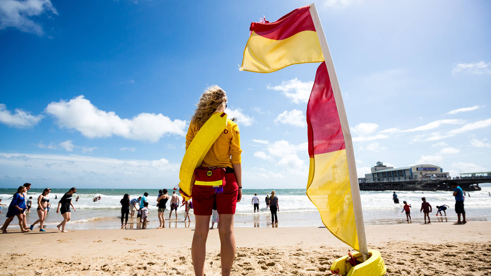 Woman Lifeguard Standing Beside Flag Background