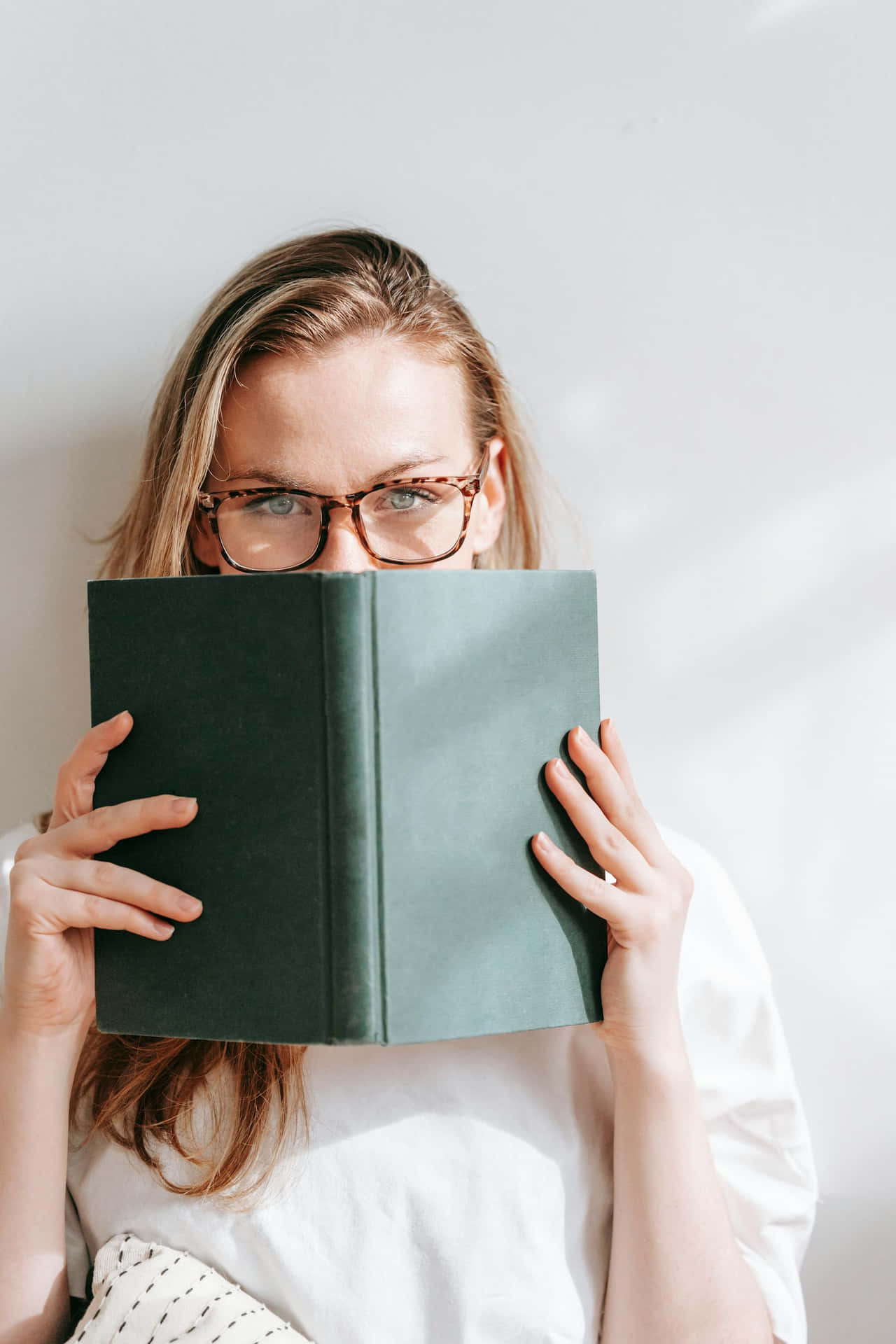 Woman Peeking Over Book