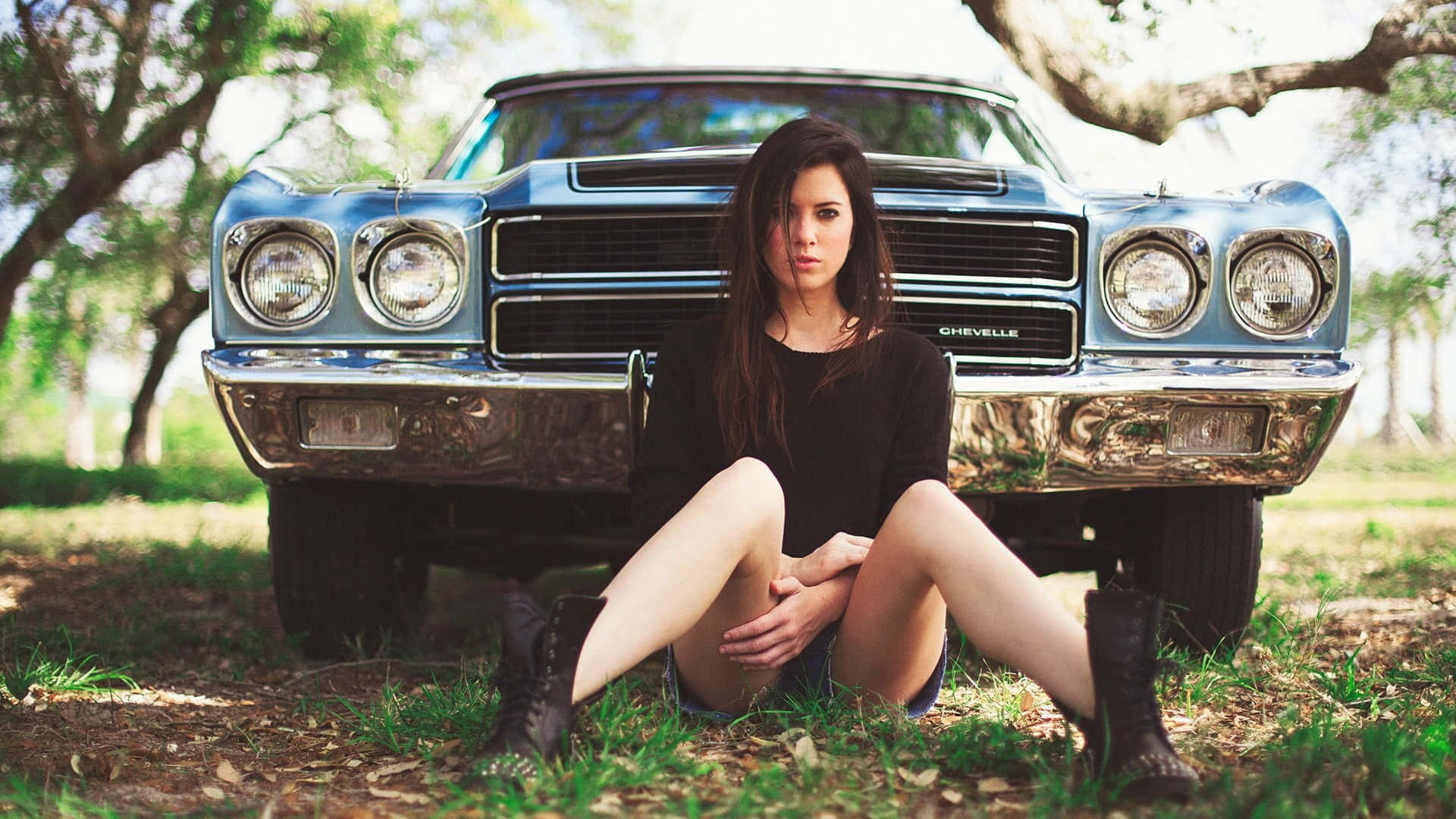 Woman Seated Before Vintage Car Background