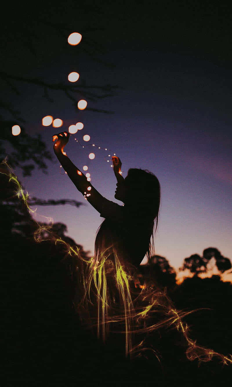 Woman Setting Up Fairy Lights During Evening