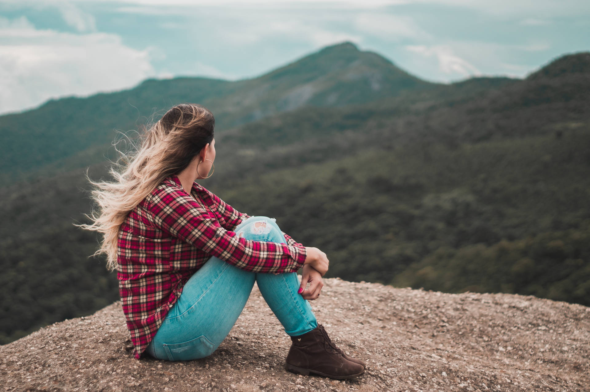 Woman Sitting Alone Near A Cliff Background