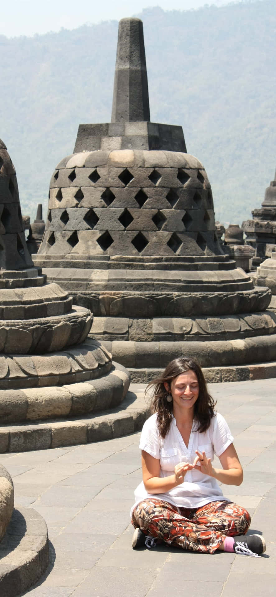 Woman Sitting On The Floor Of Borobudur Temple Background