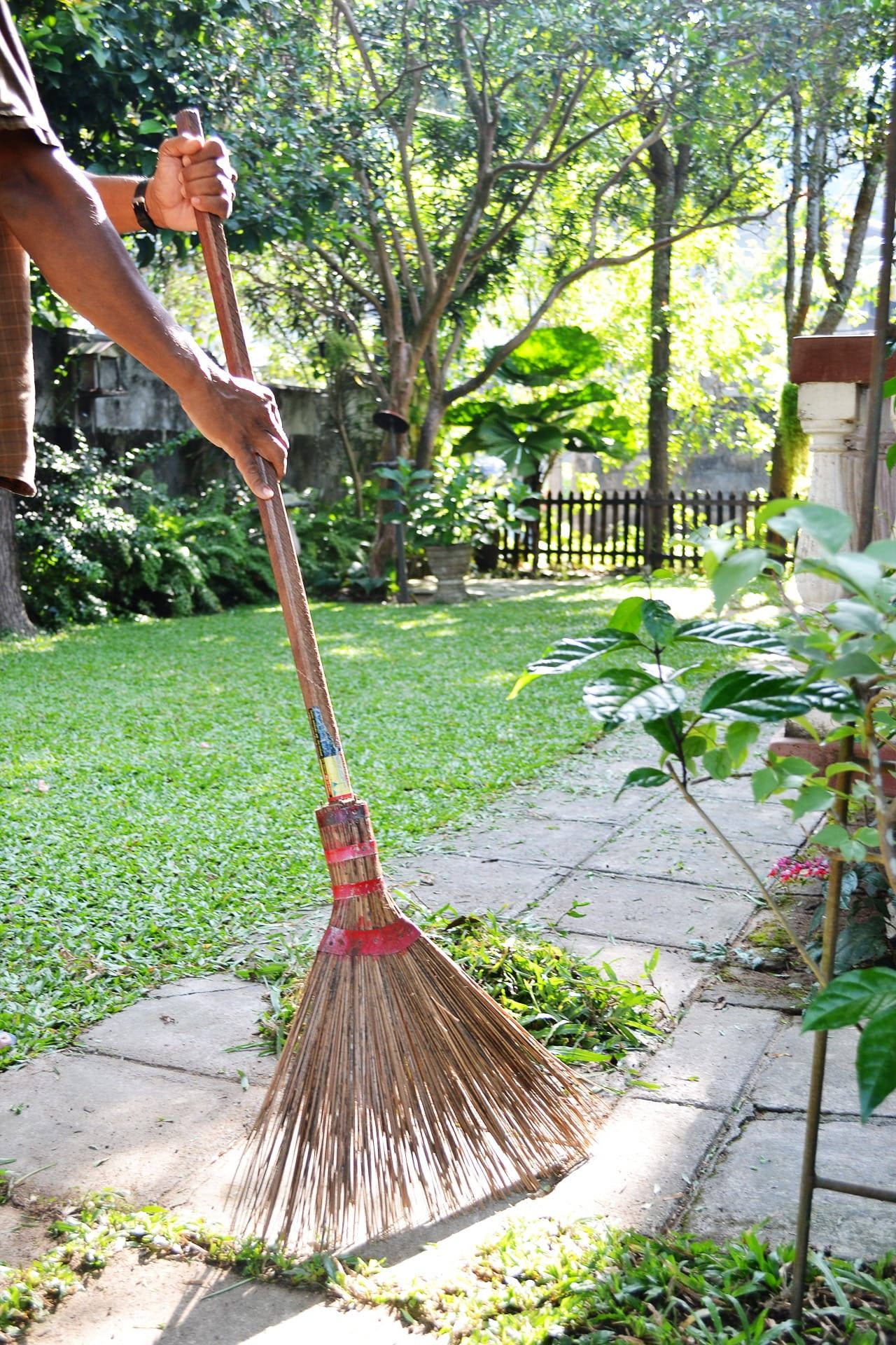 Woman Sweeping Backyard - A Domestic Cleaning Endeavour Background