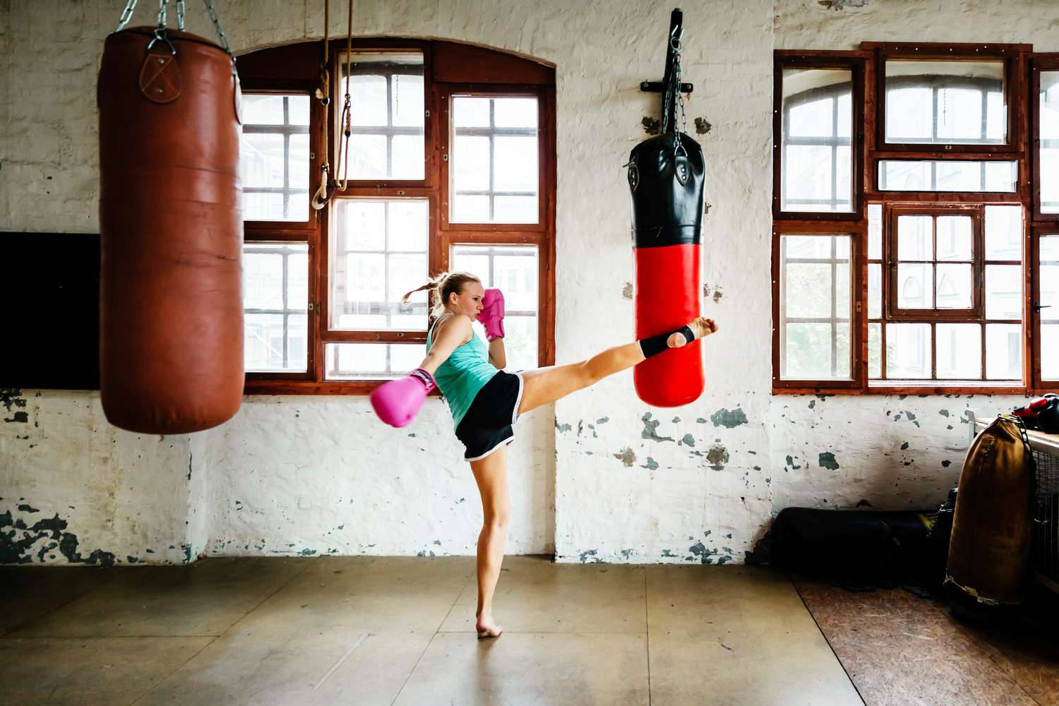 Woman Training In Kickboxing Using A Punching Bag