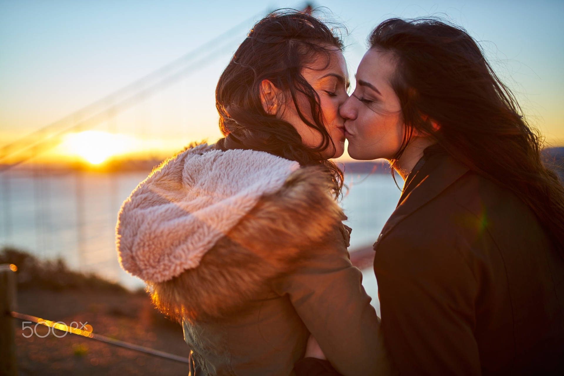 Women Kissing Near Sea Background