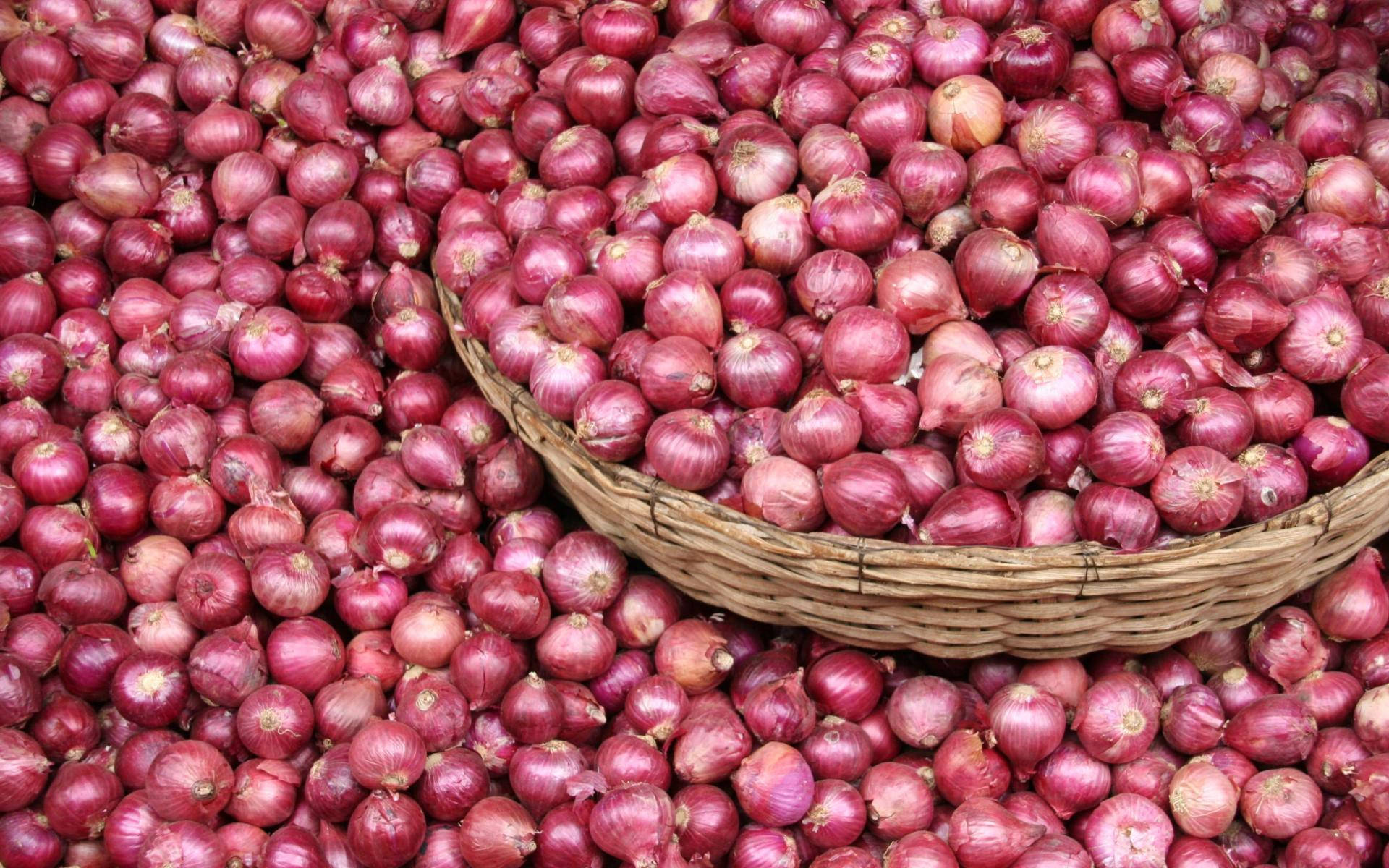 Wooden Basket Overflowing With Red Onions Background