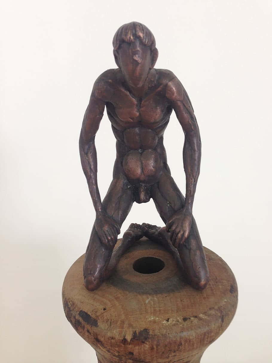 Wooden Figure Crouchingon Pot Background