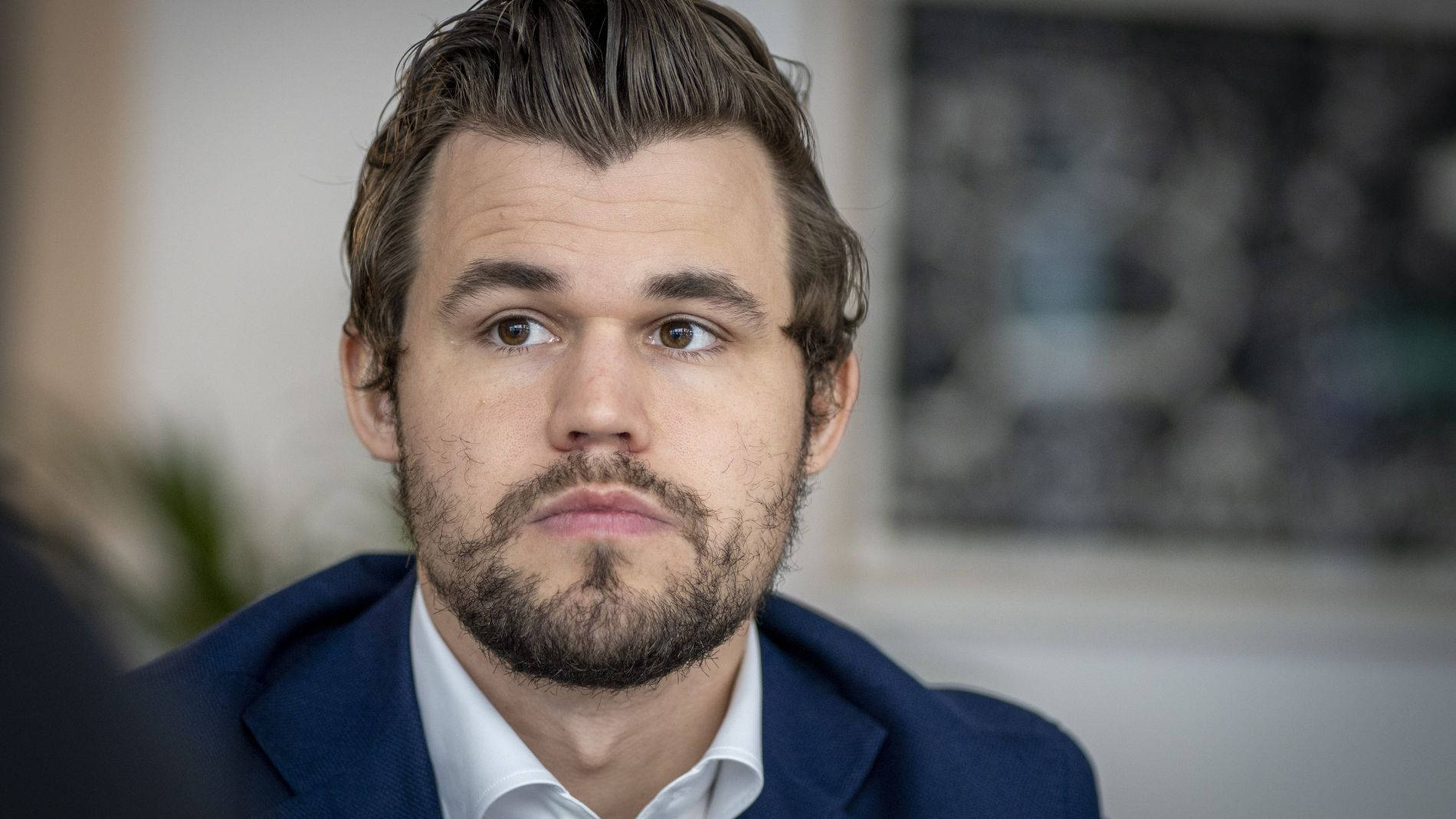 World Chess Champion Magnus Carlsen Posing With A Beard Background