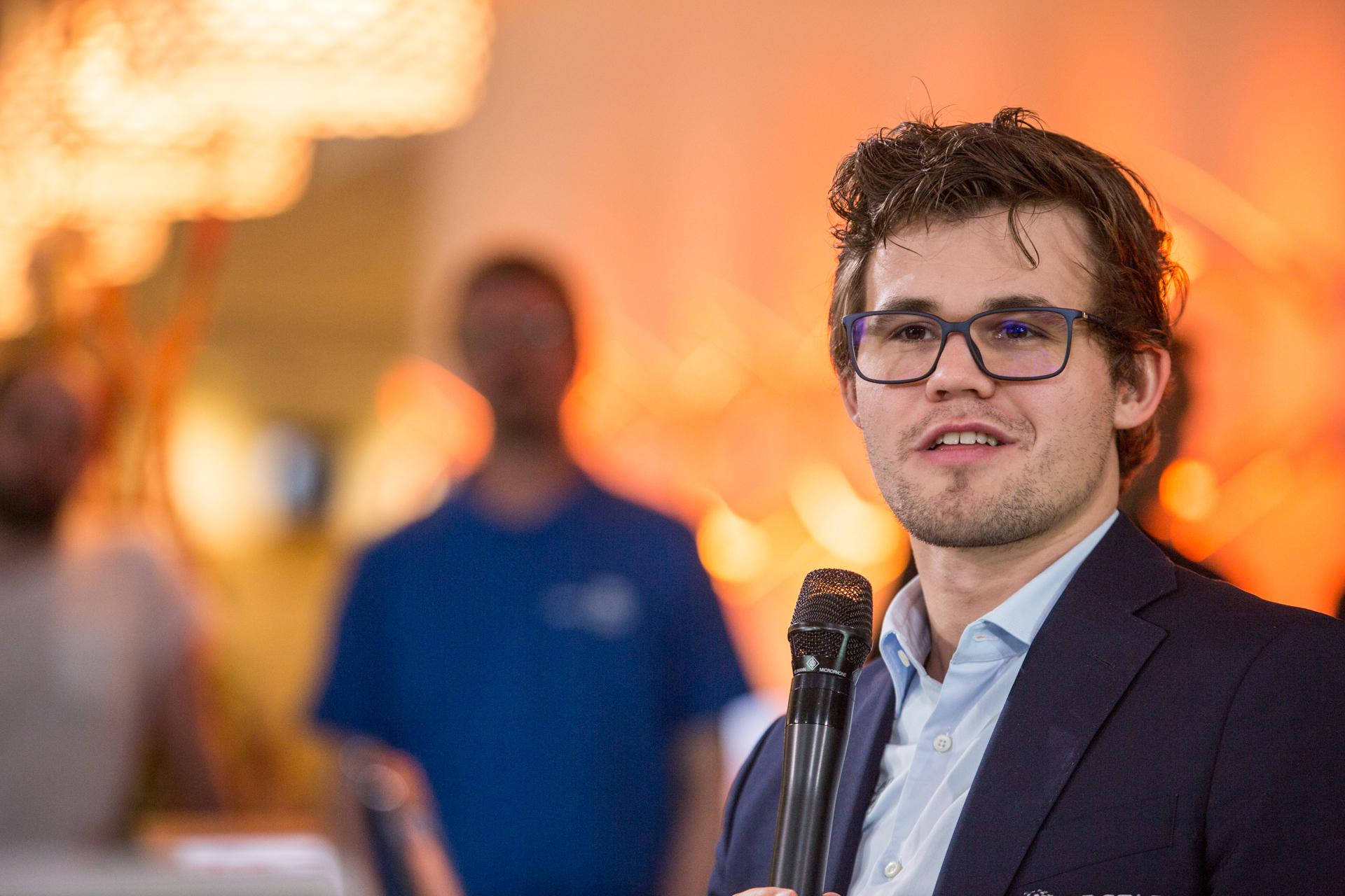 World Chess Champion Magnus Carlsen Speaking At An Event Background